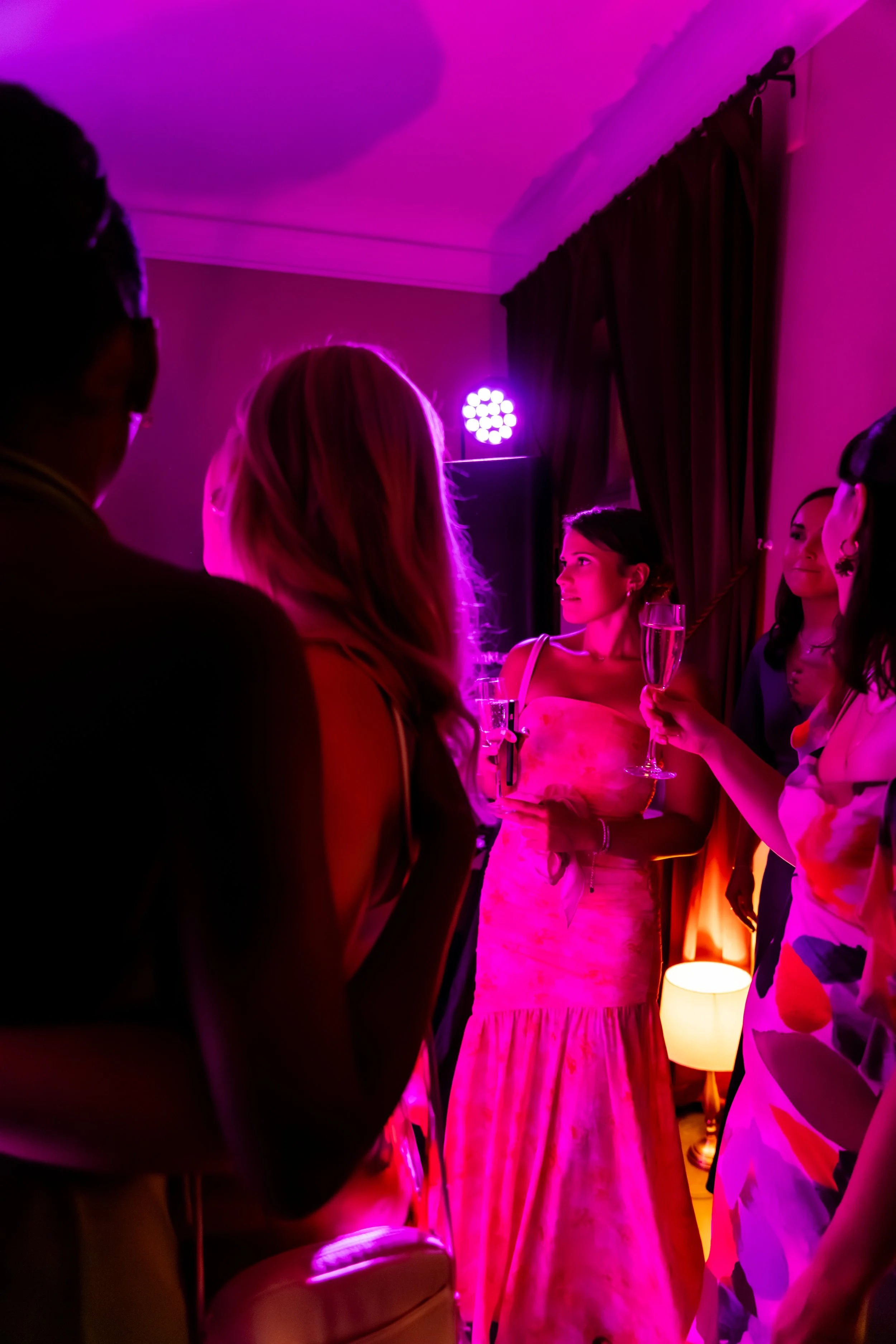 Kaunis nainen juhlimassa häiden jatkoilla. Kuvassa biletunnelma ja hauskat pinkit valot.