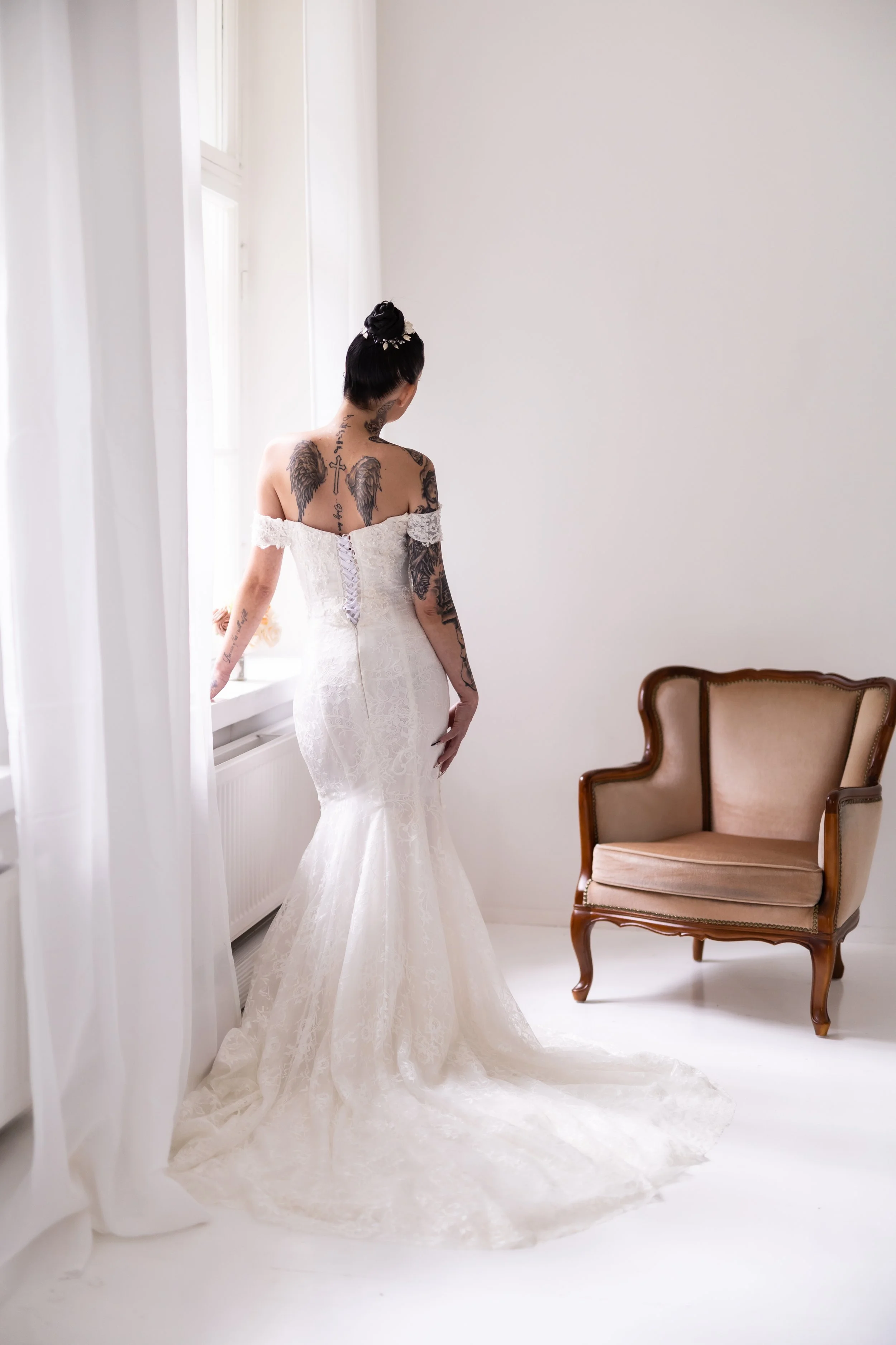 Nainen seisoo hääpuvussa valokuvaaja Julia Karppisen studiolla Lahdessa. Pitkä kaunis laahus ja kaunis kampaus. 