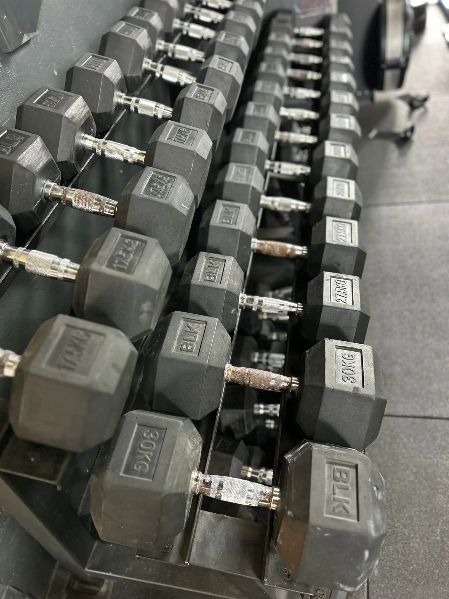 Dumbbells arranged on a rack in a gym.