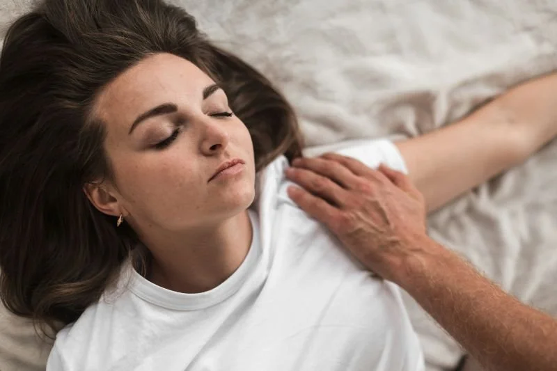Zwangere vrouw krijgt een zachte shiatsu-massage, een moment van diepe ontspanning en ondersteuning tijdens de zwangerschap.