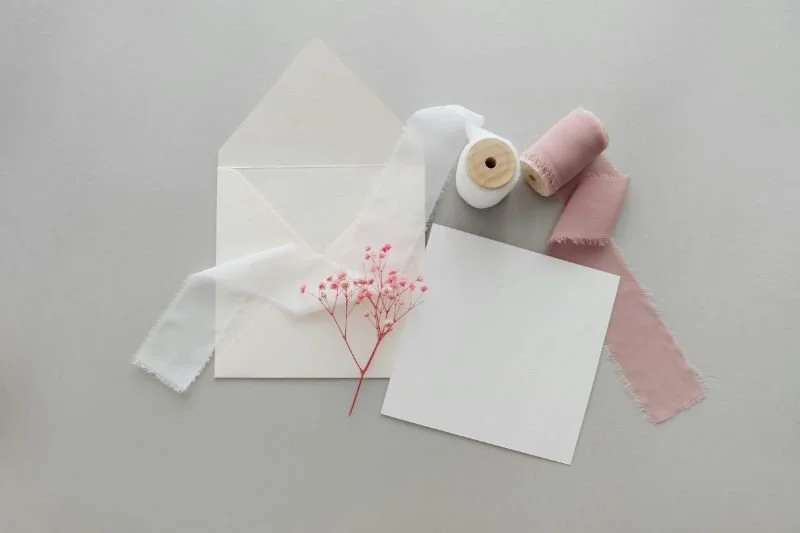 Luxe cadeaubon met envelop, lint en droogbloem – een origineel babycadeau van Bed en Baby.