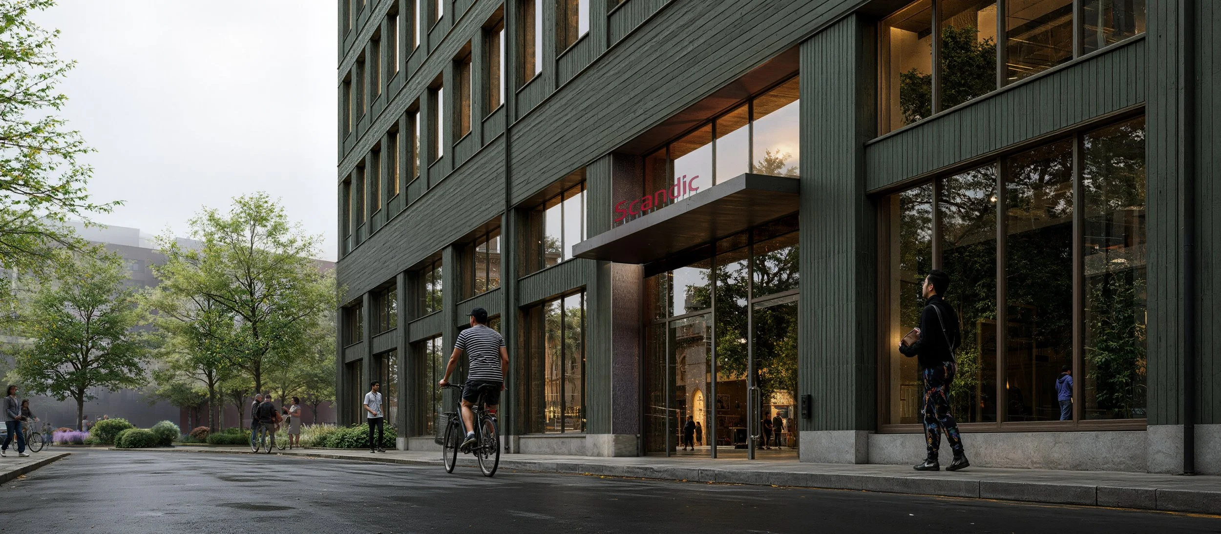 Två trevåningshus av tegel med balkonger, parkerade bilar framför, tidig kväll eller skymning, utomhusbelysning.