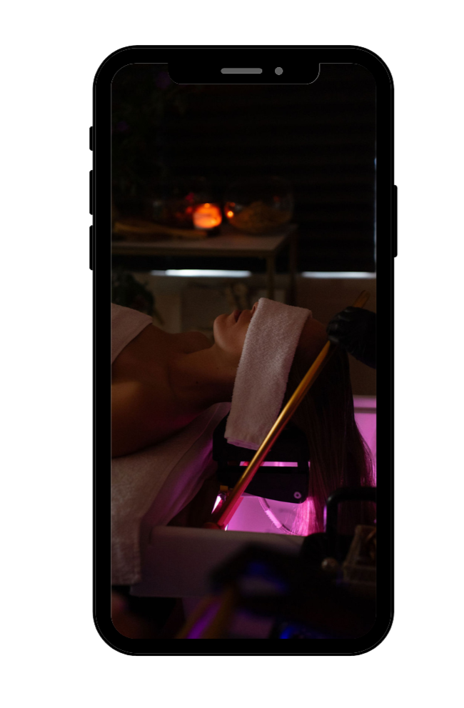 Persoon krijgt een gezichtsbehandeling, liggend met een handdoek over het hoofd in een spa of schoonheidssalon.