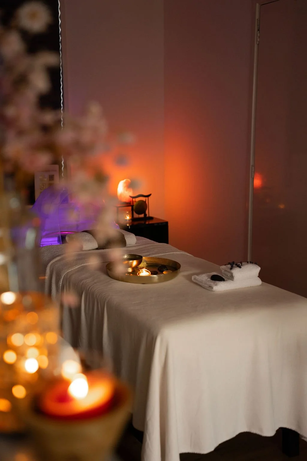 Een ontspanningsruimte met een massagebed, kaarsen, en zachte verlichting voor een rustgevende sfeer. Japanse headspa massage. Selfcare moment