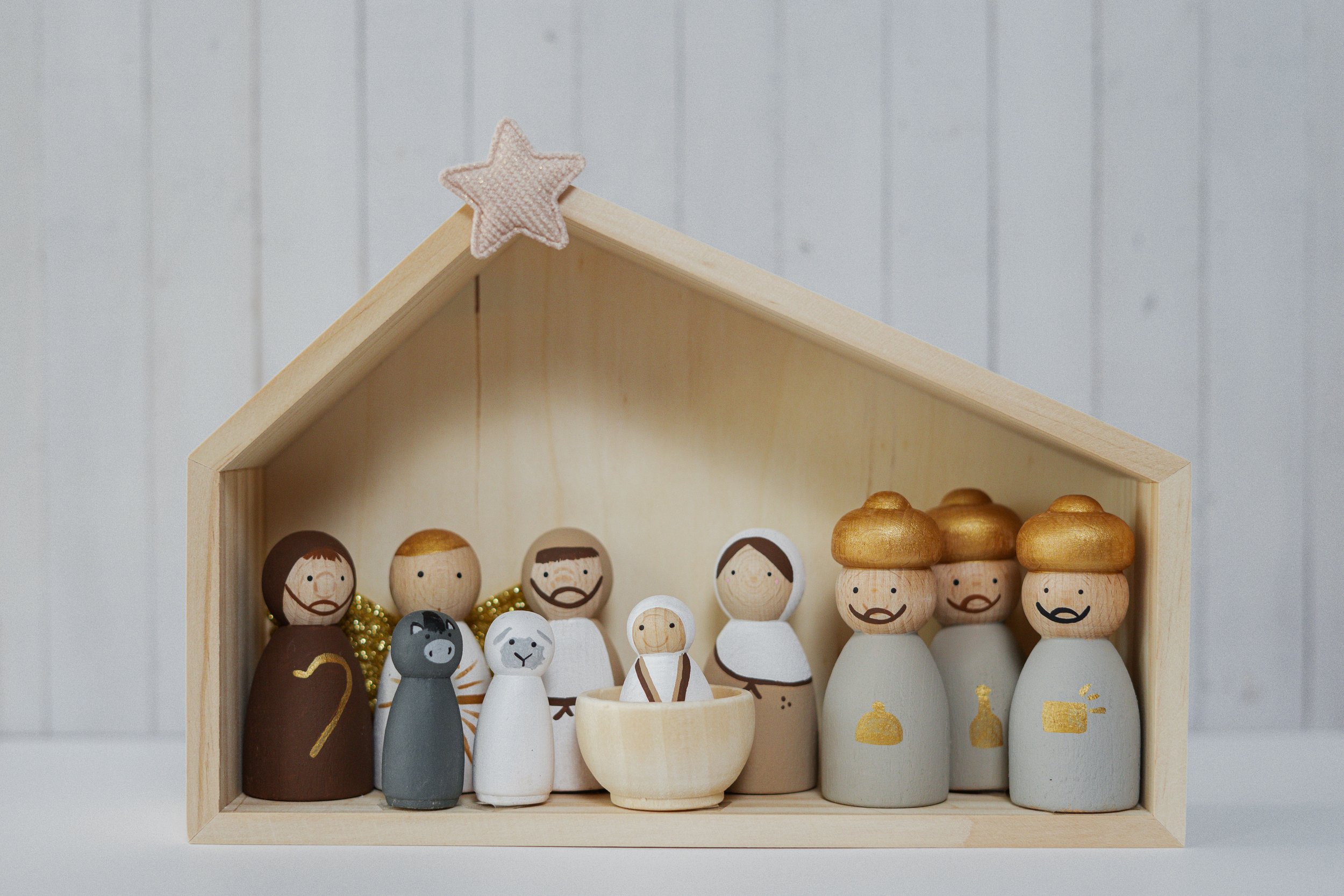 Natuurlijk houten kerststal met figuren van Jezus, Maria, Jozef, de drie wijzen en herders in een houten schuur, versierd met een ster. Kerstcadeau