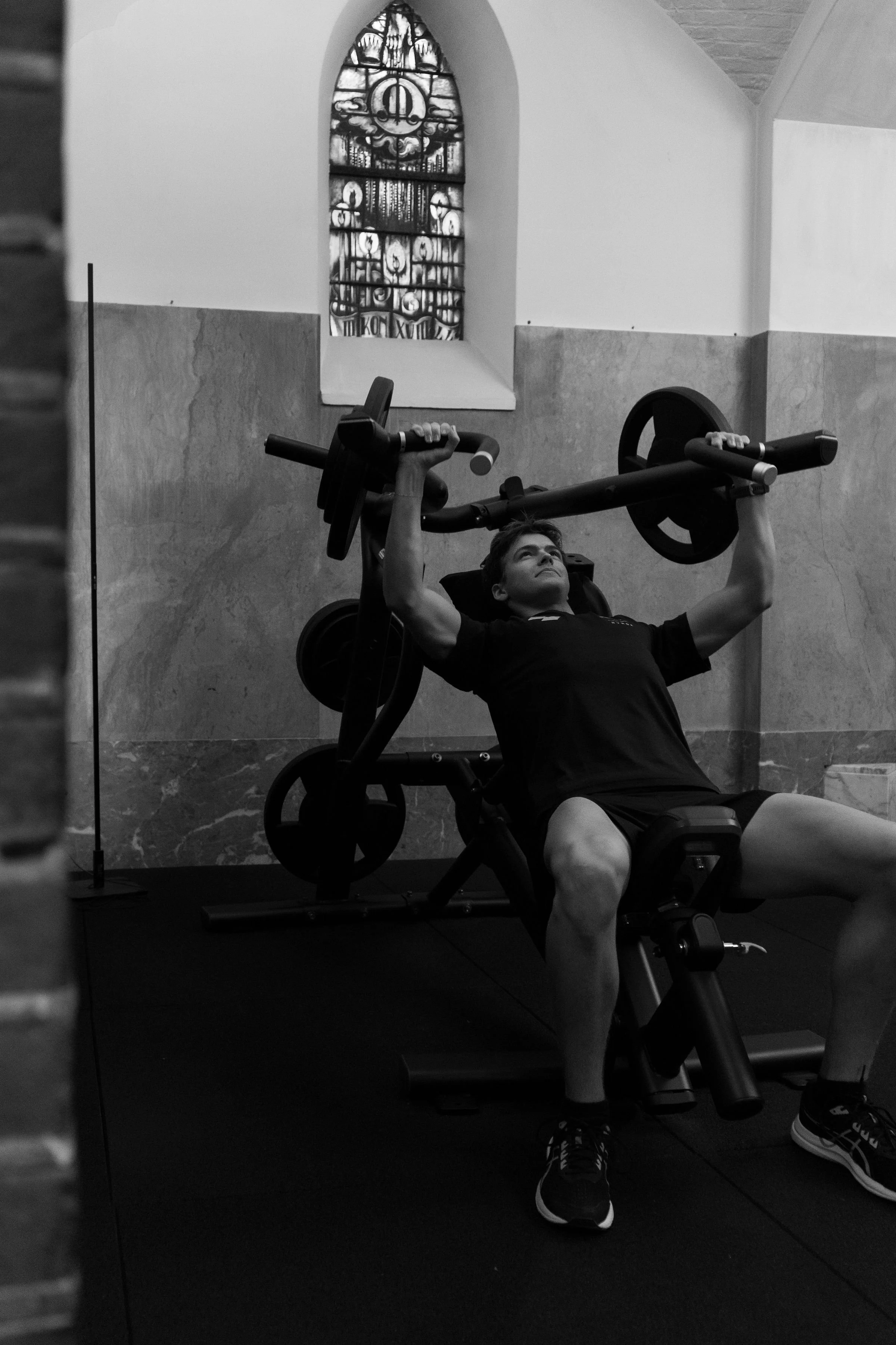 Man doet schoulderpress in de sportschool. Sporthanddoek. Locktowel.