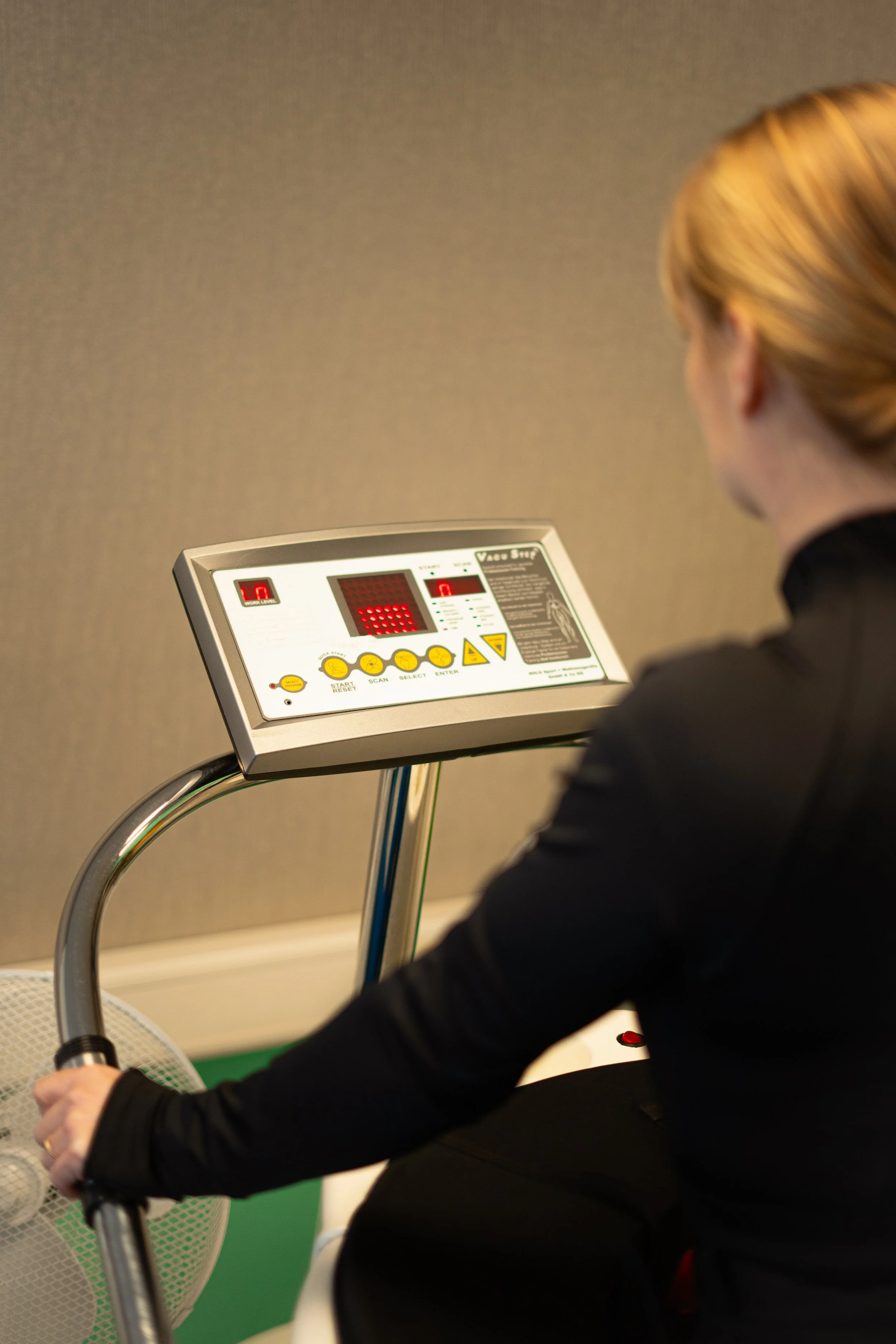 Persoon die een ventilator bedient met een digitale controlepaneel.