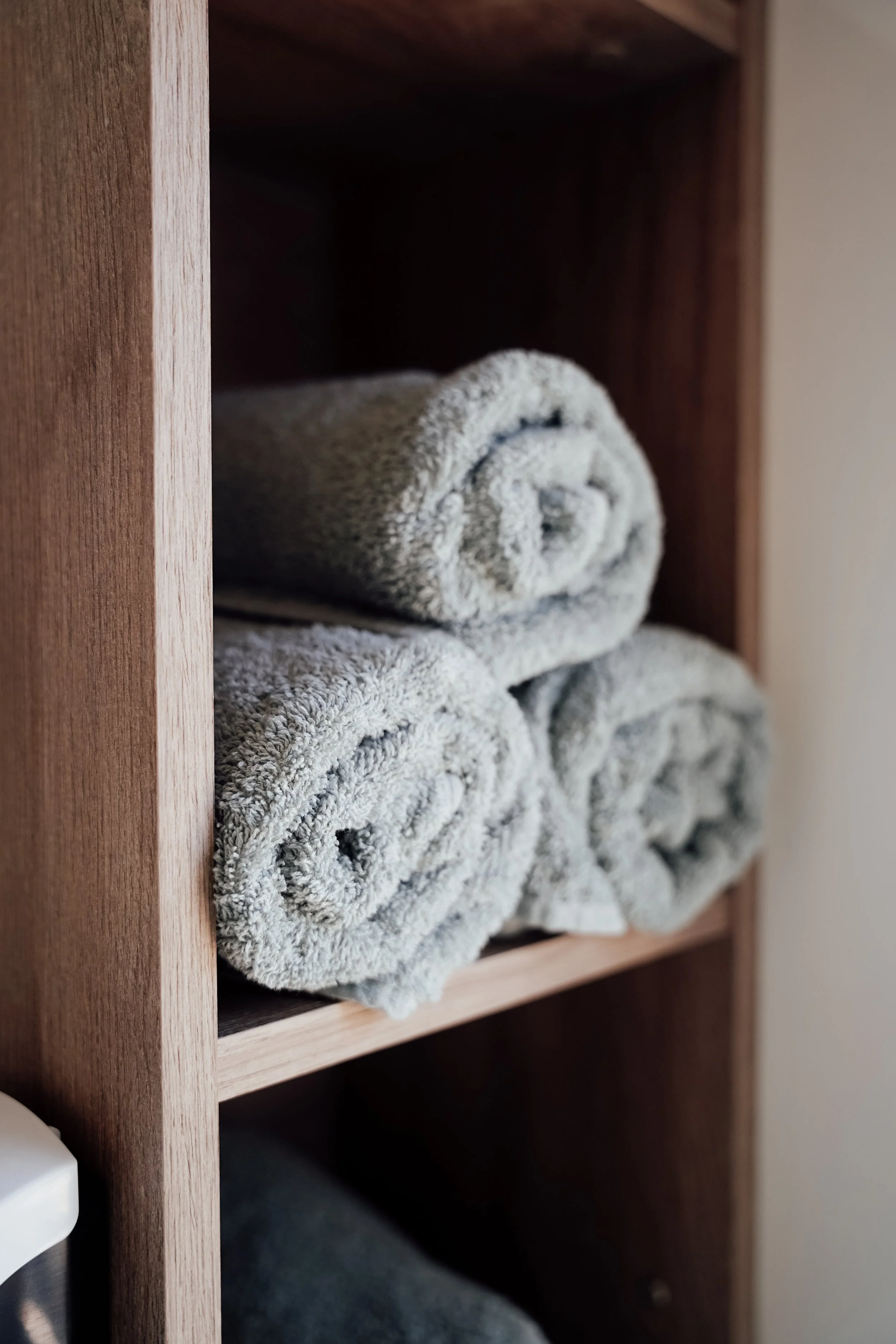 Geverfde handdoeken op een houten plank in een kast. Vakantiepark. Chalet.