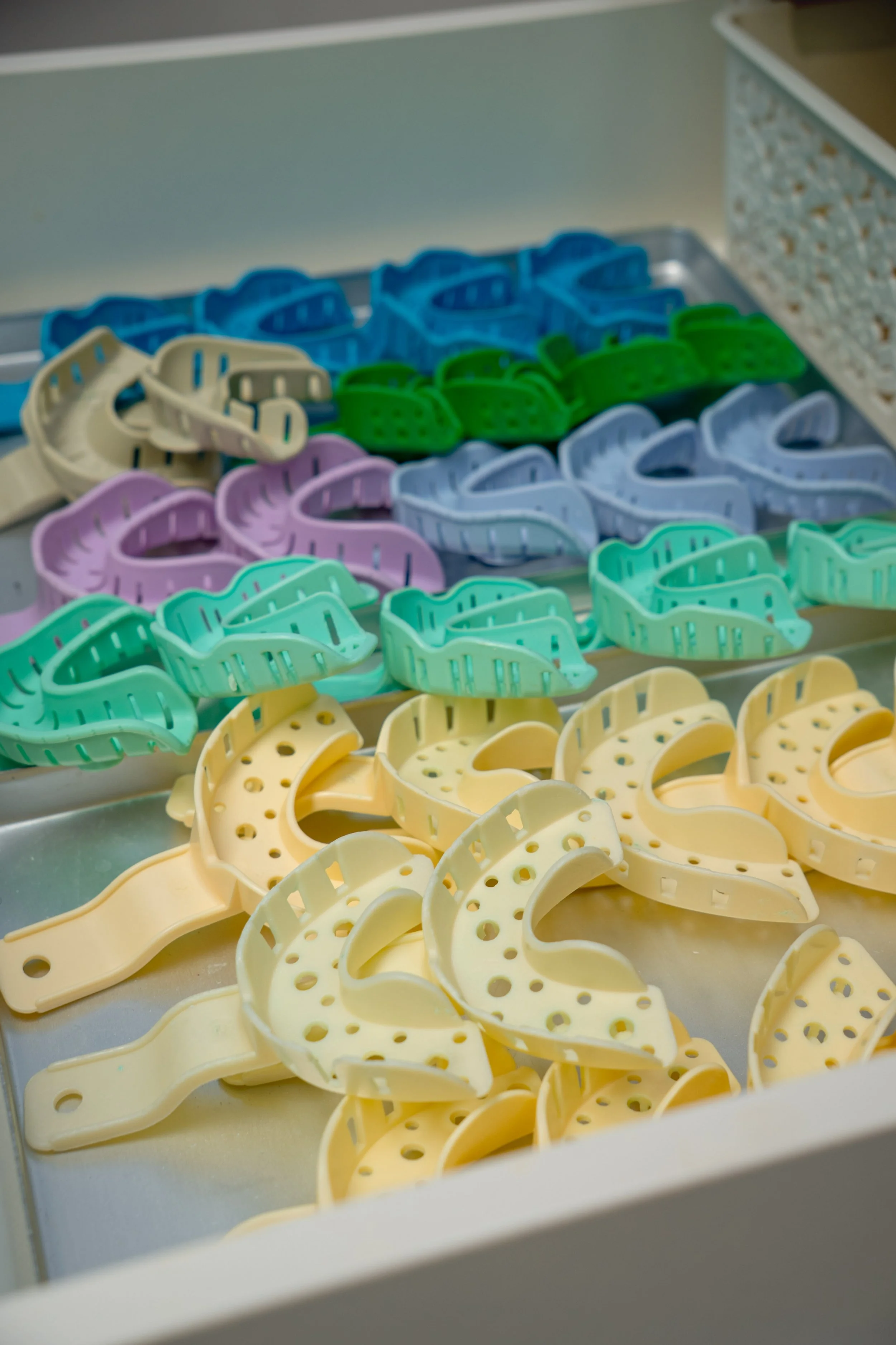 Kleurrijke orthodontische beugels in verschillende kleuren liggen in een lade.