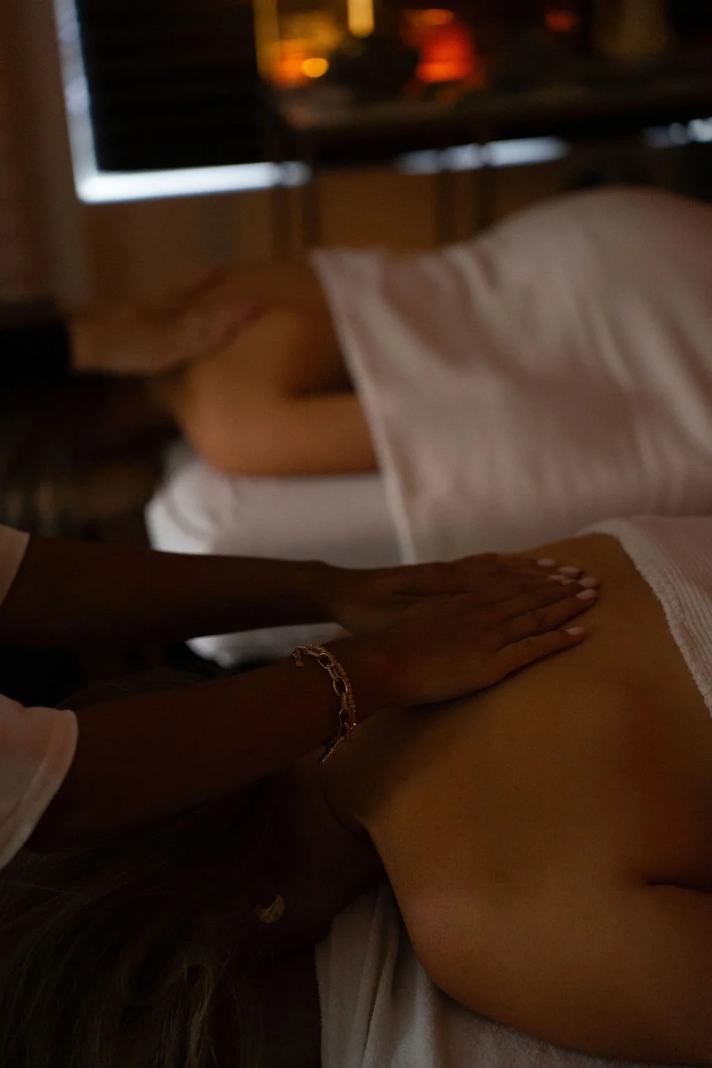 Persoon krijgt een massage in een rustige kamer met een tv en ramen op de achtergrond. Japanse headspa massage. Selfcare moment