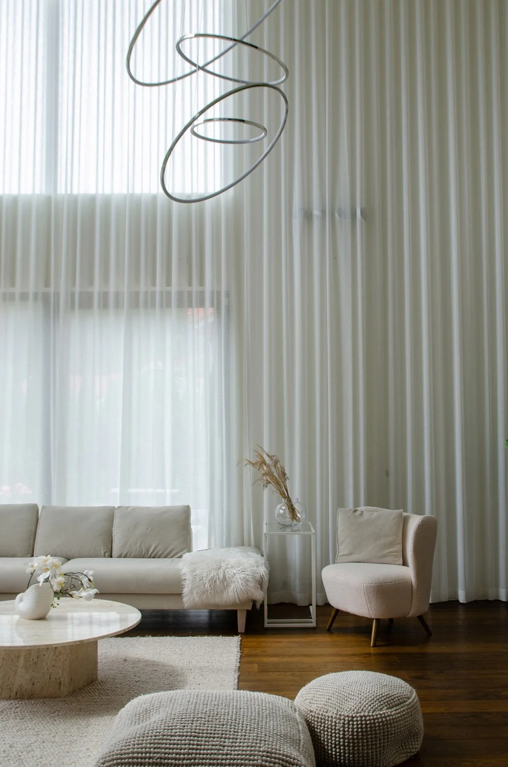 Korkea olohuone, isolla valaisimella ja istuinryhmällä.