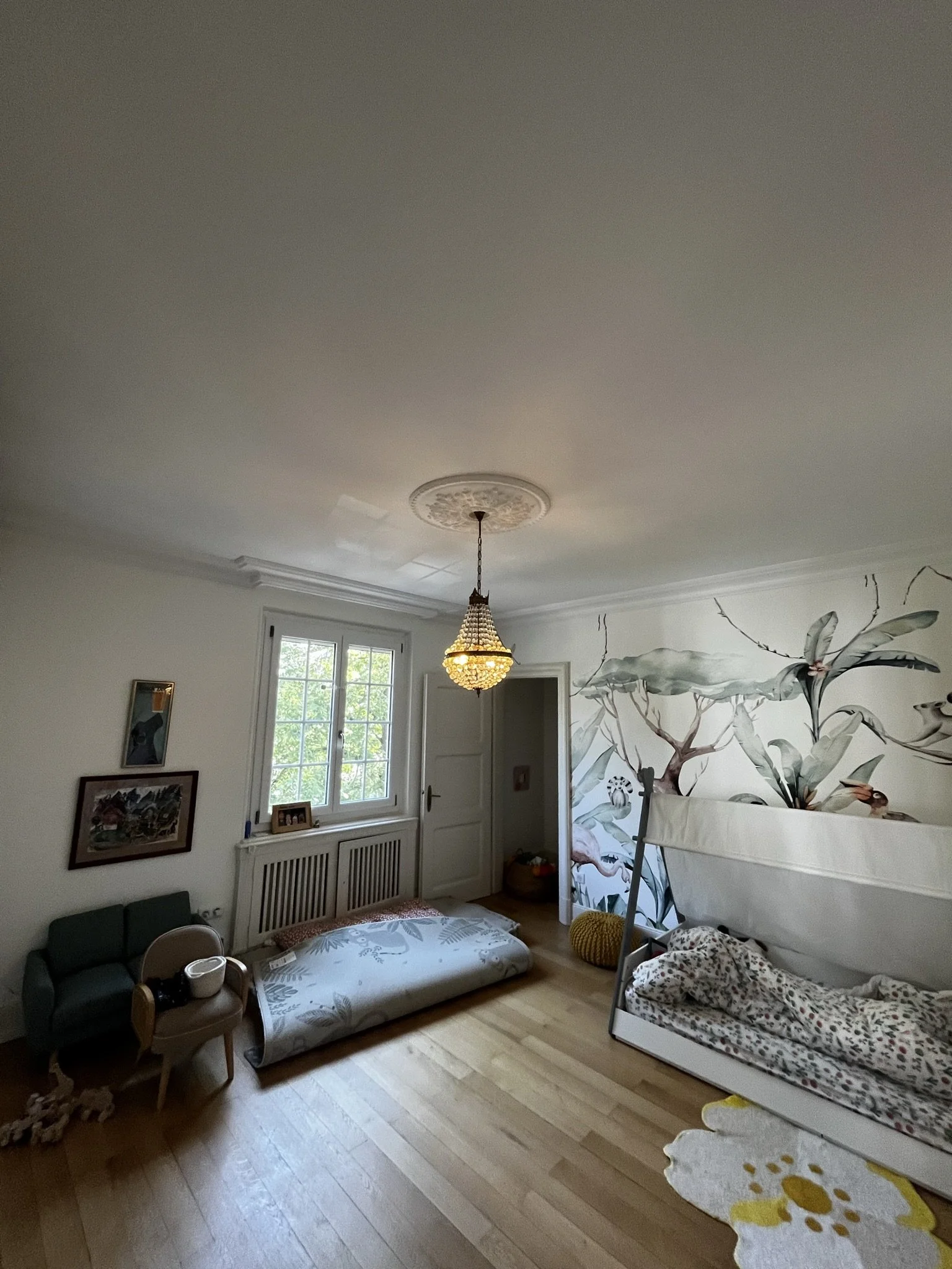 Chambre d'enfant avec un plafond en plâtre avec des corniches et une rosace centrale