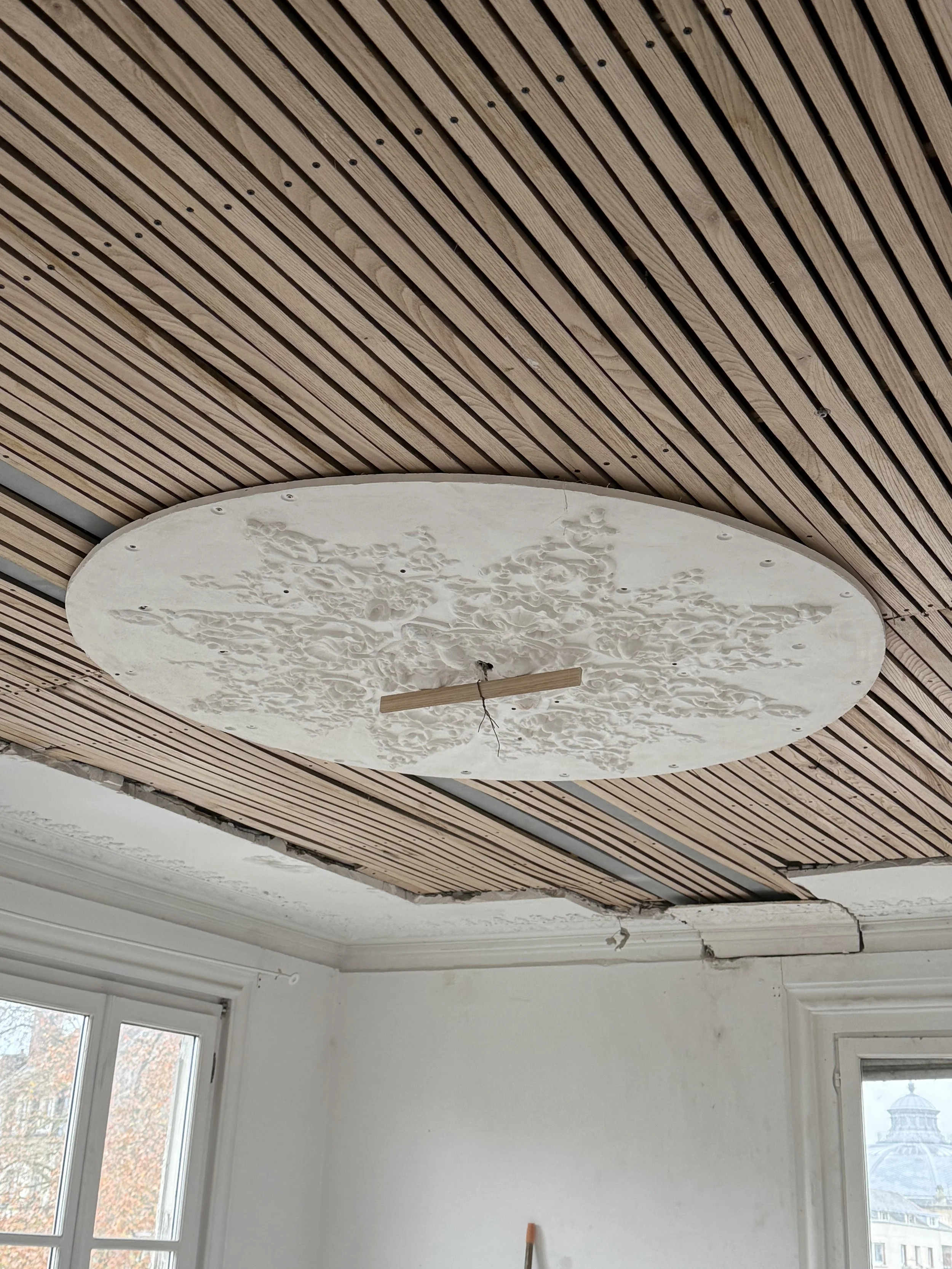 Travaux de rénovation au plafond d'une pièce, installation de la rosace