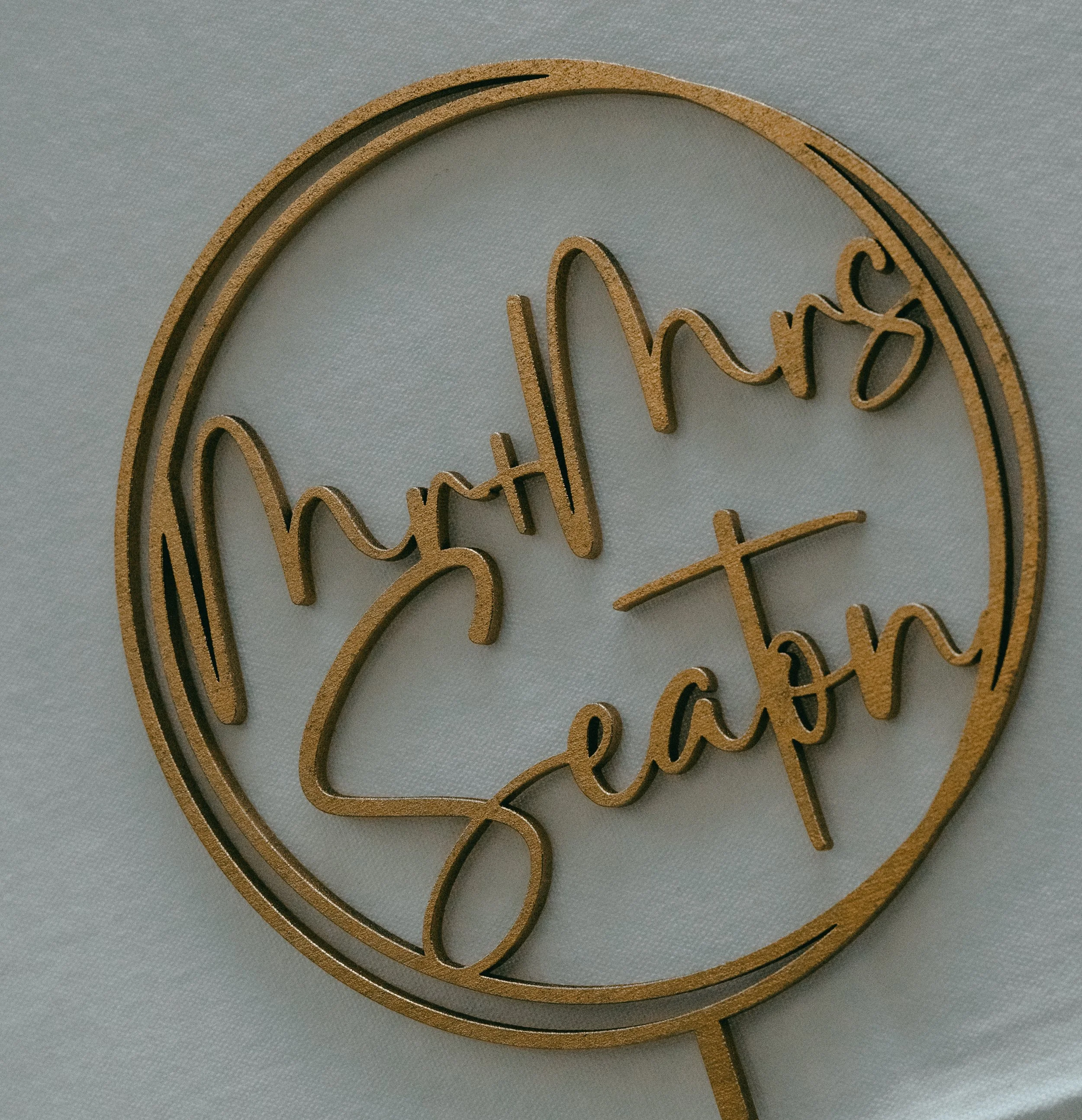 Close-up of a decorative wall sign with the word 'chocolate' written in cursive, made of layered wood with a light background.
