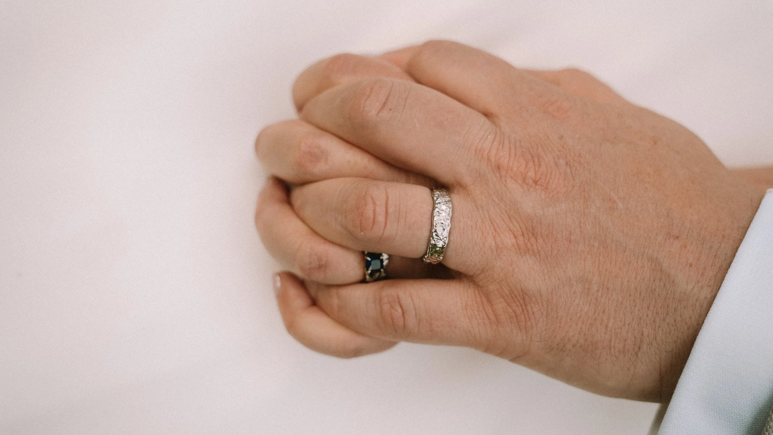 Close-up of a person's hand with rings, resting on a white surface after their wedding in Chesterfield.