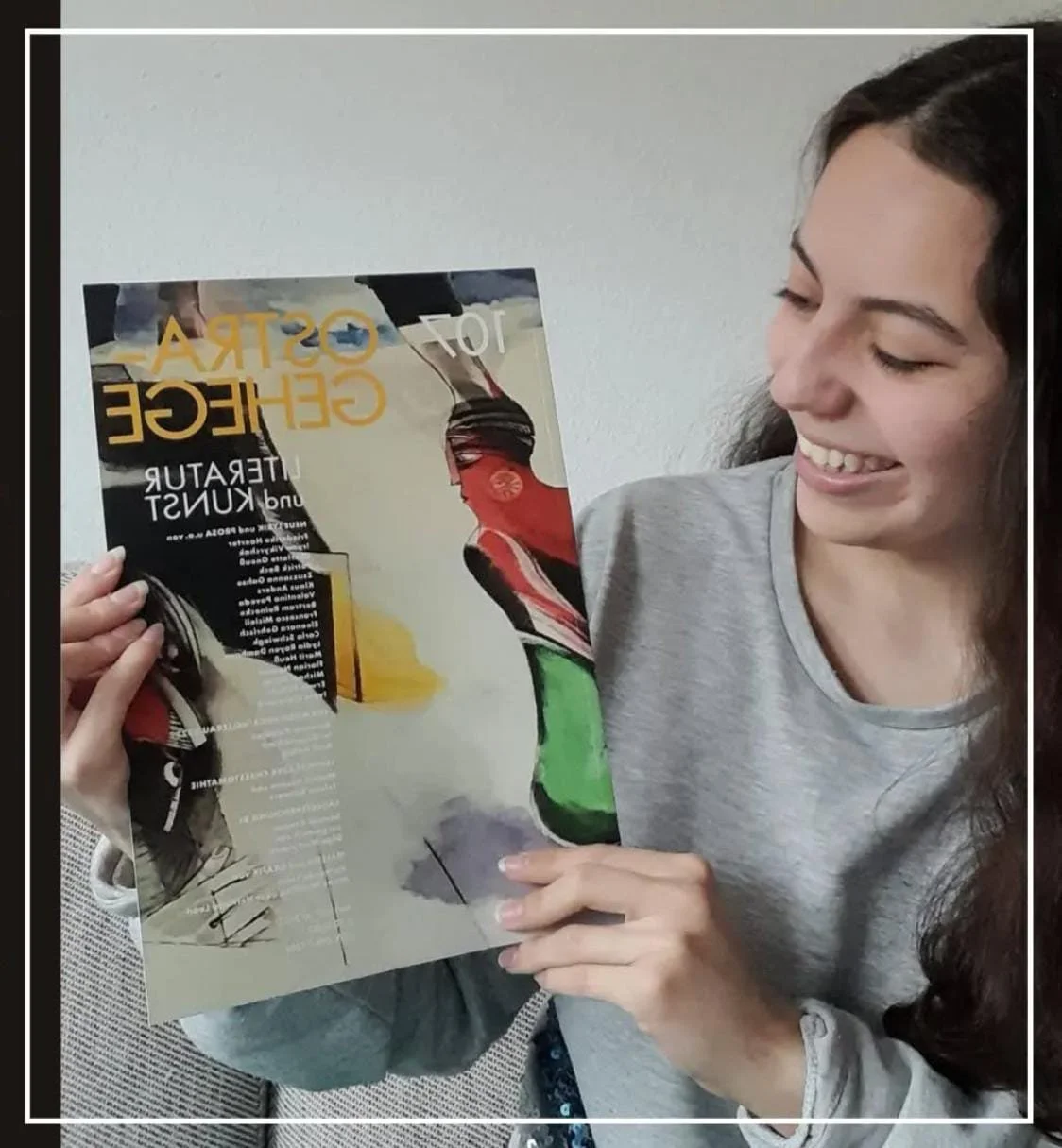 Eine lachende Frau hält die Zeitschrift "Ostragehege" in den Händen.