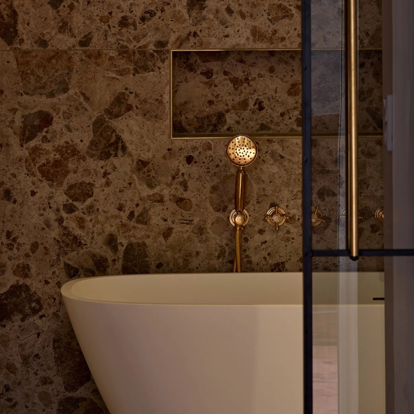 Ro i detaljen
Et badev&aelig;relse kan v&aelig;re mere end funktion &ndash; det kan v&aelig;re et fristed.
Her m&oslash;des naturstenens struktur, det varme gyldne armatur og det enkle hvide badekar i en stille balance.

Hos Evoke Media arbejder vi n