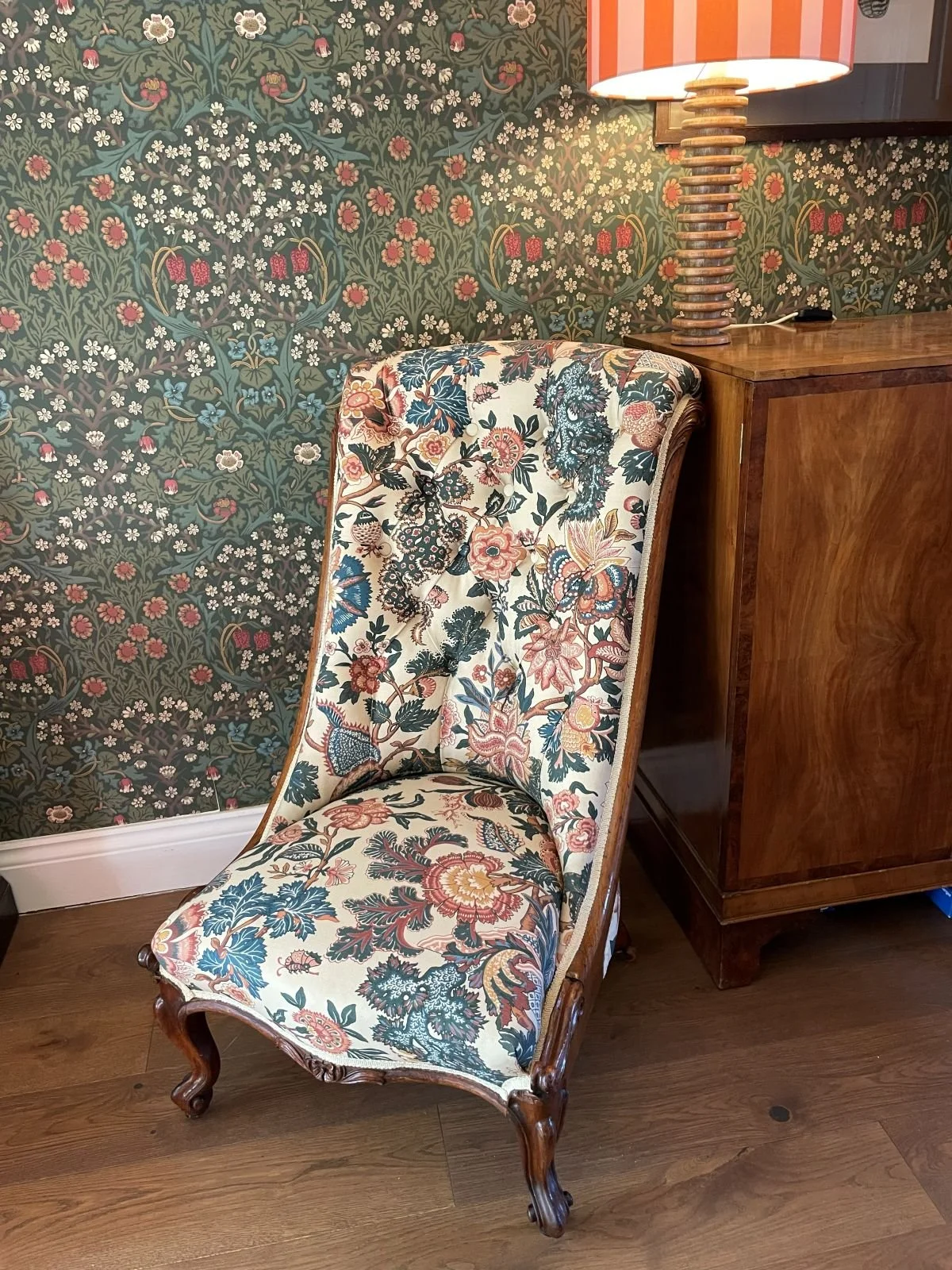 Victorian nursing chair covered in bold floral fabric