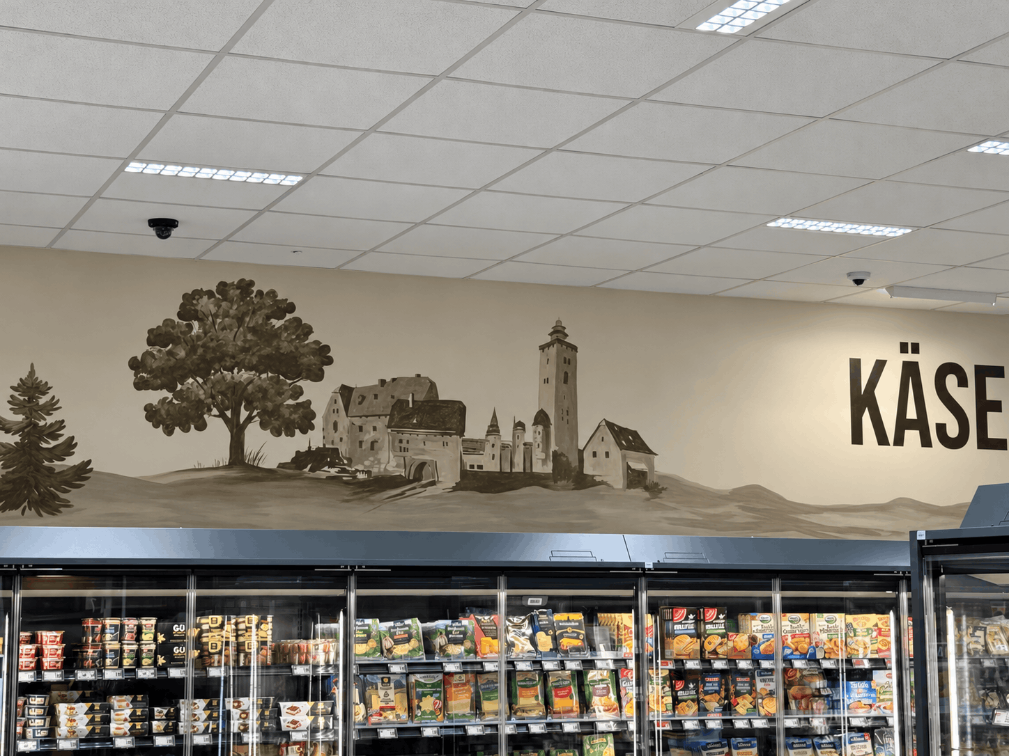 Supermarkt-Käseabteilung mit Wandgemälde.png