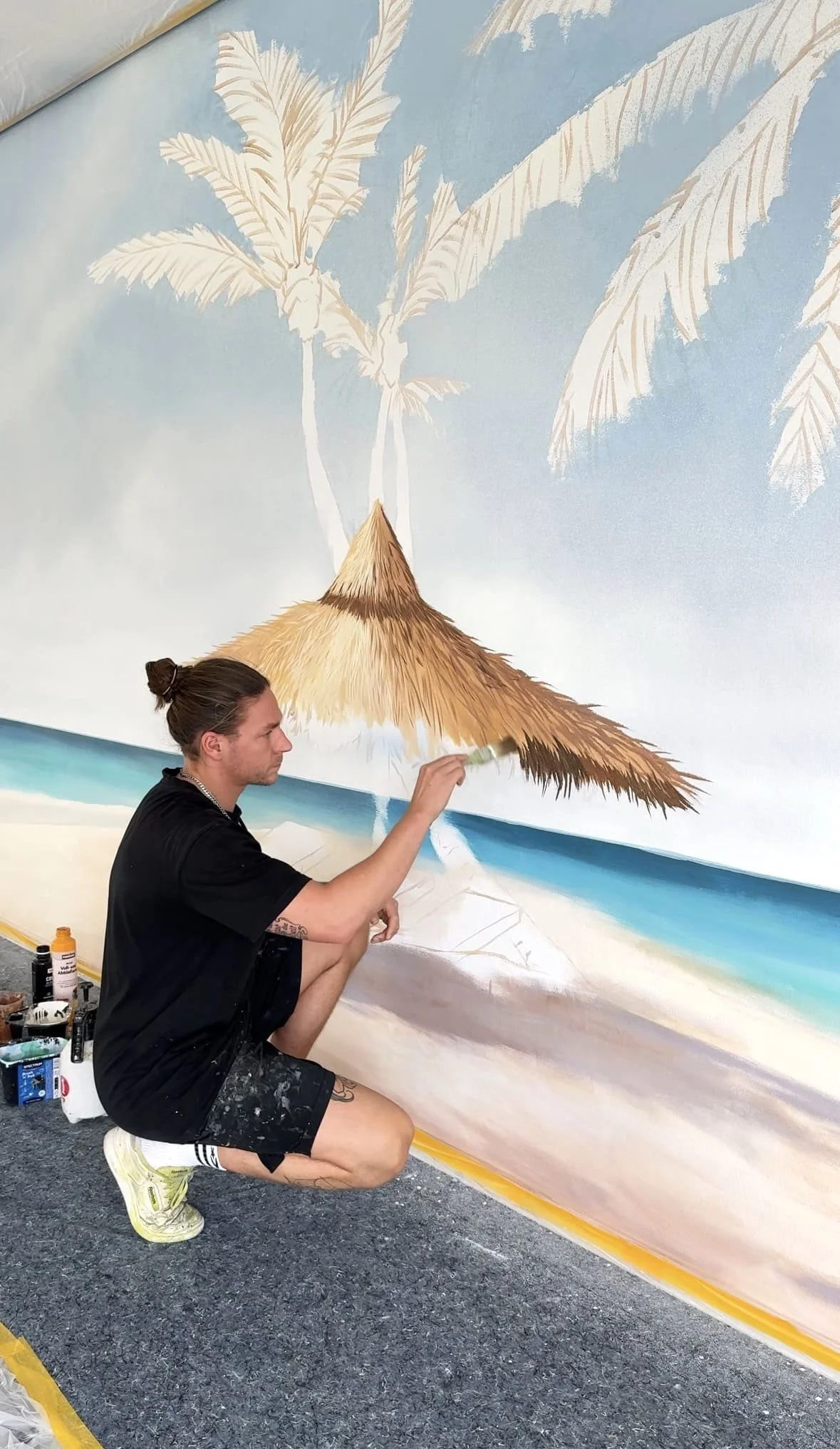 Florian Erb beim Malen der fotorealistischen Strand-Wandmalerei im Schwimmbad