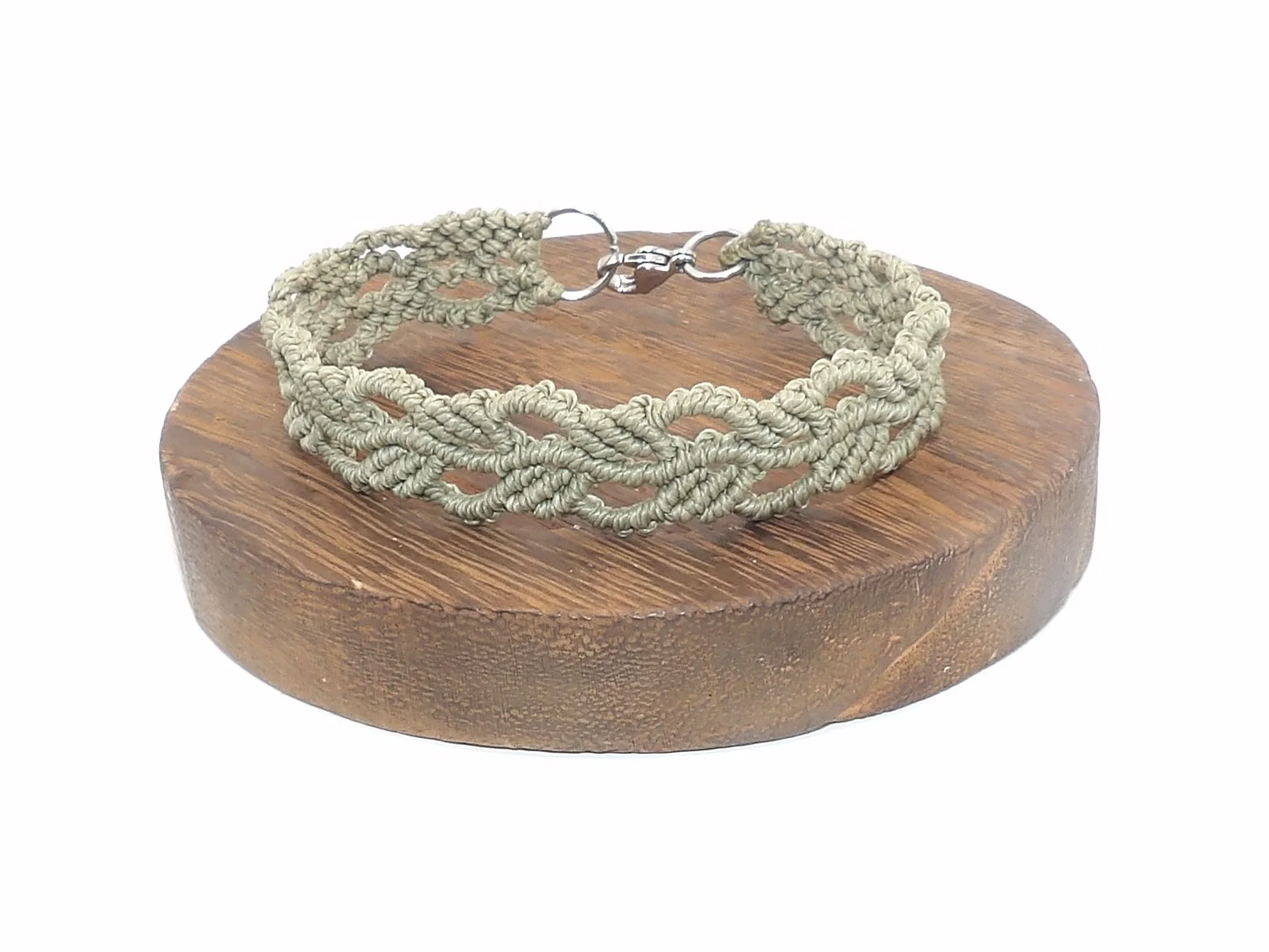A close-up of a green woven ivy leaf bracelet, highlighting the detailed knotwork of the micromacrame leaves and the shine of the 304 stainless steel clasp.