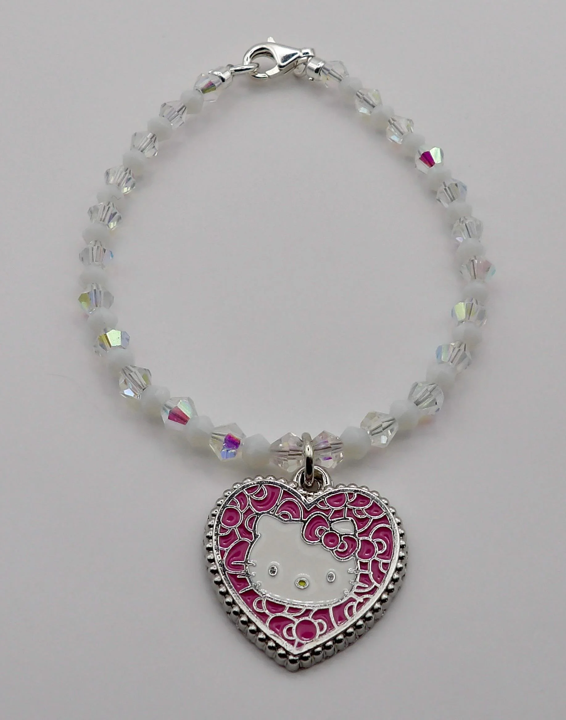 a high-end kawaii-style bracelet showing a shimmering pink heart charm paired with light-catching aurora borealis crystals.