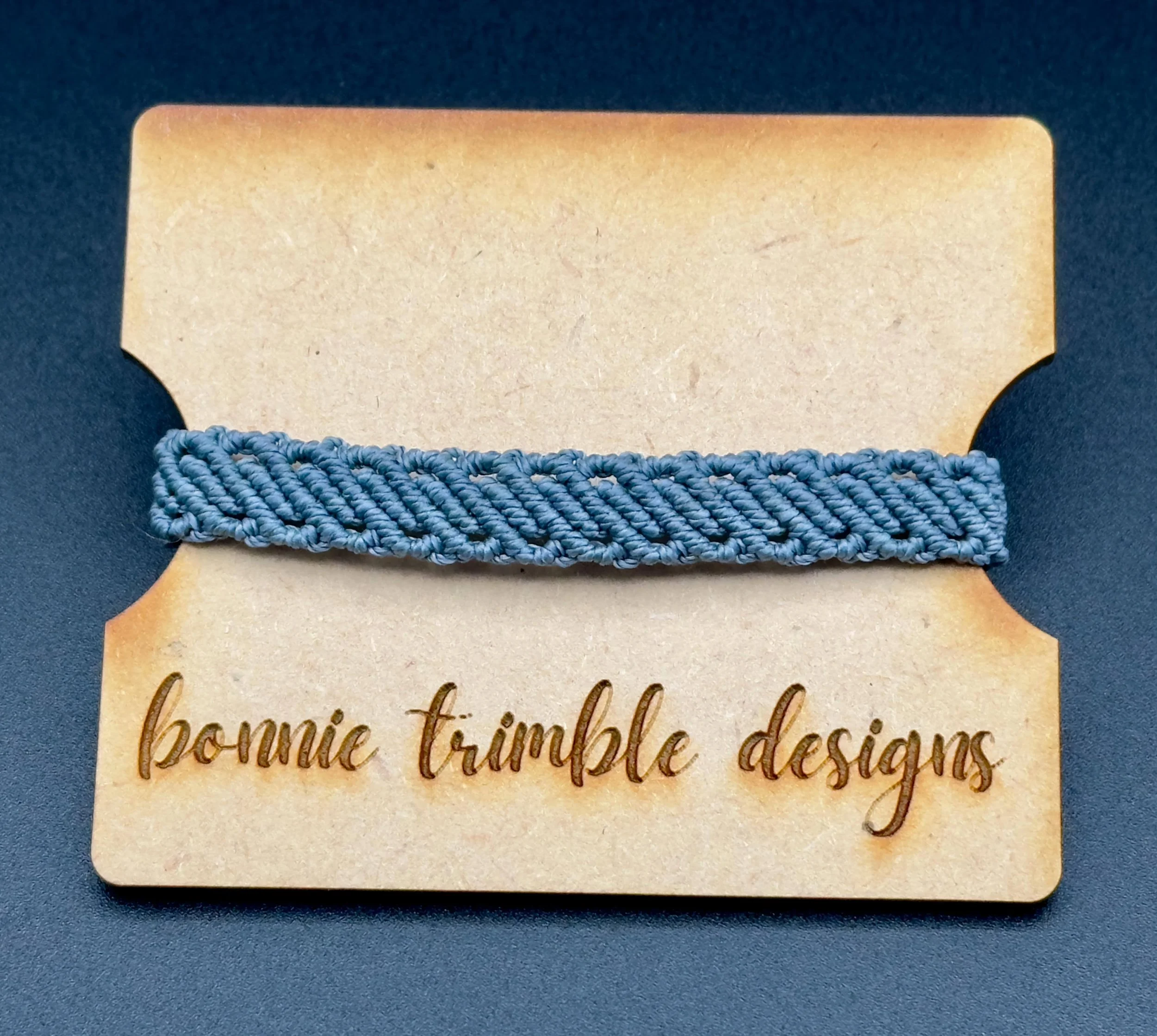 close-up of the gray waxed cord micro macrame bracelet showing the intricate multi-row weave.