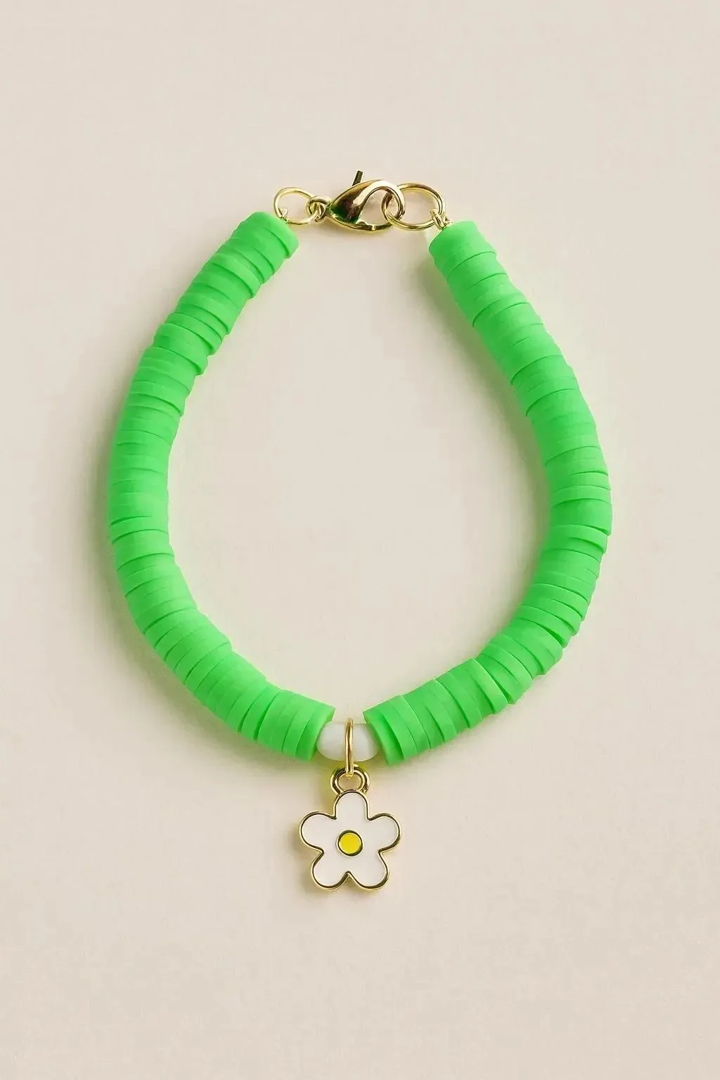 a cheerful and high-quality "preppy-luxe" bracelet showing the contrast of bright green beads and a central gold floral focal.