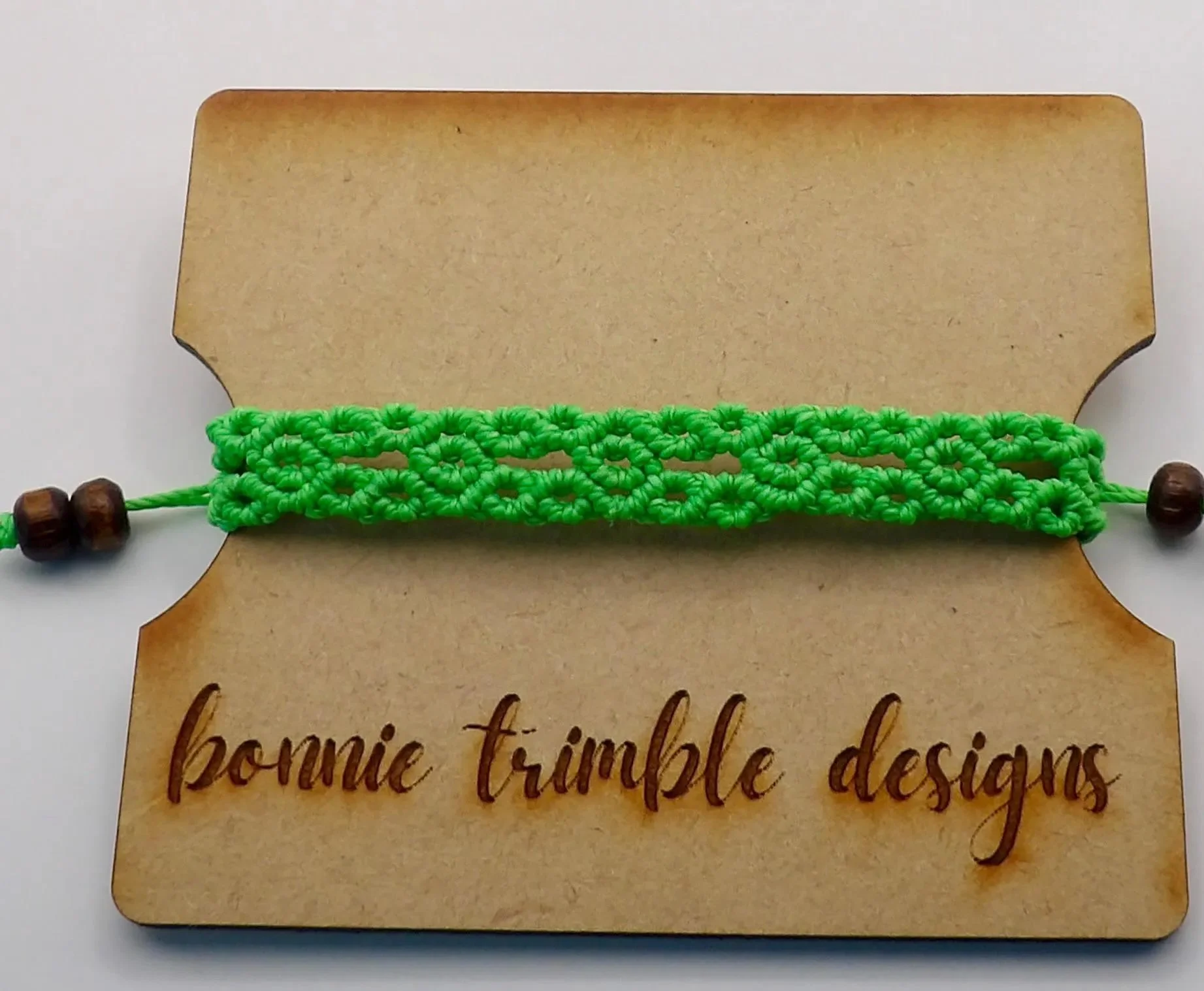 natural wood and micro-macramé bracelet with a geometric focal point and a soft, organic texture.