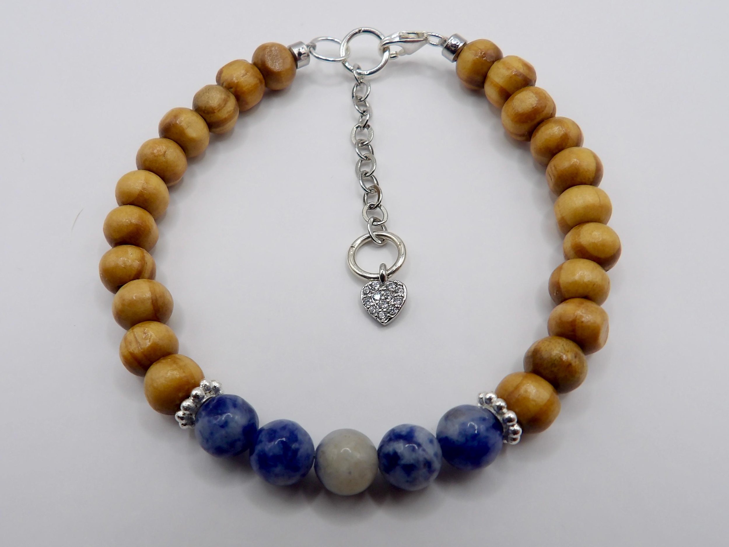 a versatile mixed-media anchor bracelet designed with durable cord, natural wood, and high-shine platinum-plated hardware.