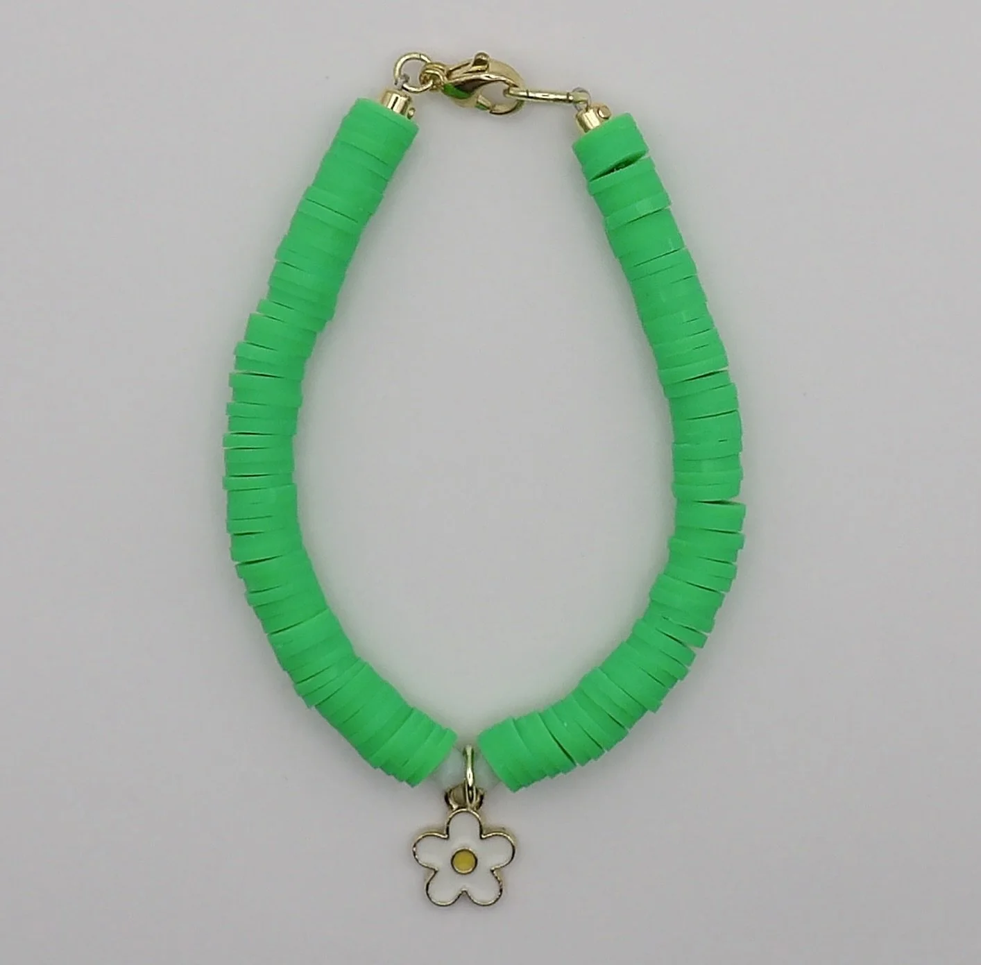handmade 14k solid gold daisy bracelet with grassy green polymer clay heishi beads, faceted crystal accents, and a 14k gold lobster clasp.