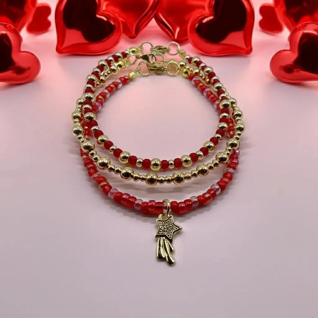 close-up of the festive starlight set highlighting the internal fire of the red glass beads next to the intricate sparkle of the pave charm.