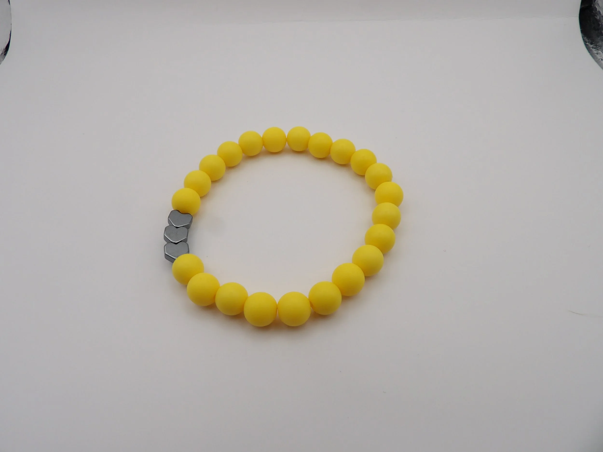 sweet dreams matte heart bracelet in canary yellow color with a shiny black heart accent bead.