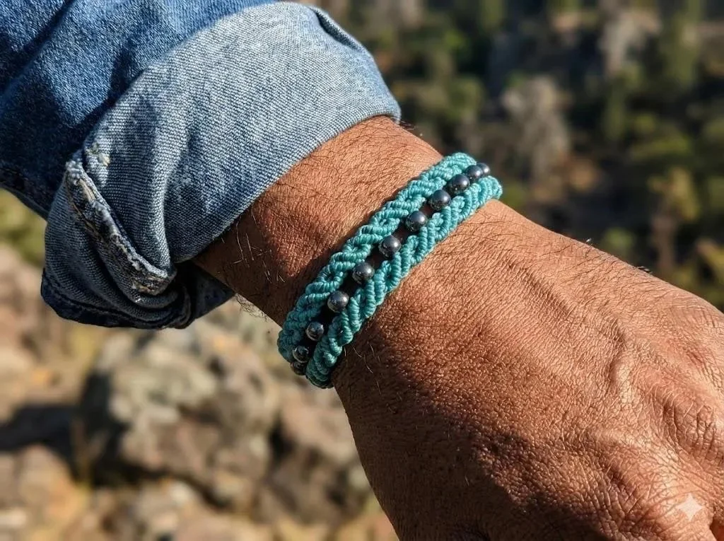 a delicate and structural hand-woven bracelet showing the intricate scalloped loops and adjustable sliding knot closure.