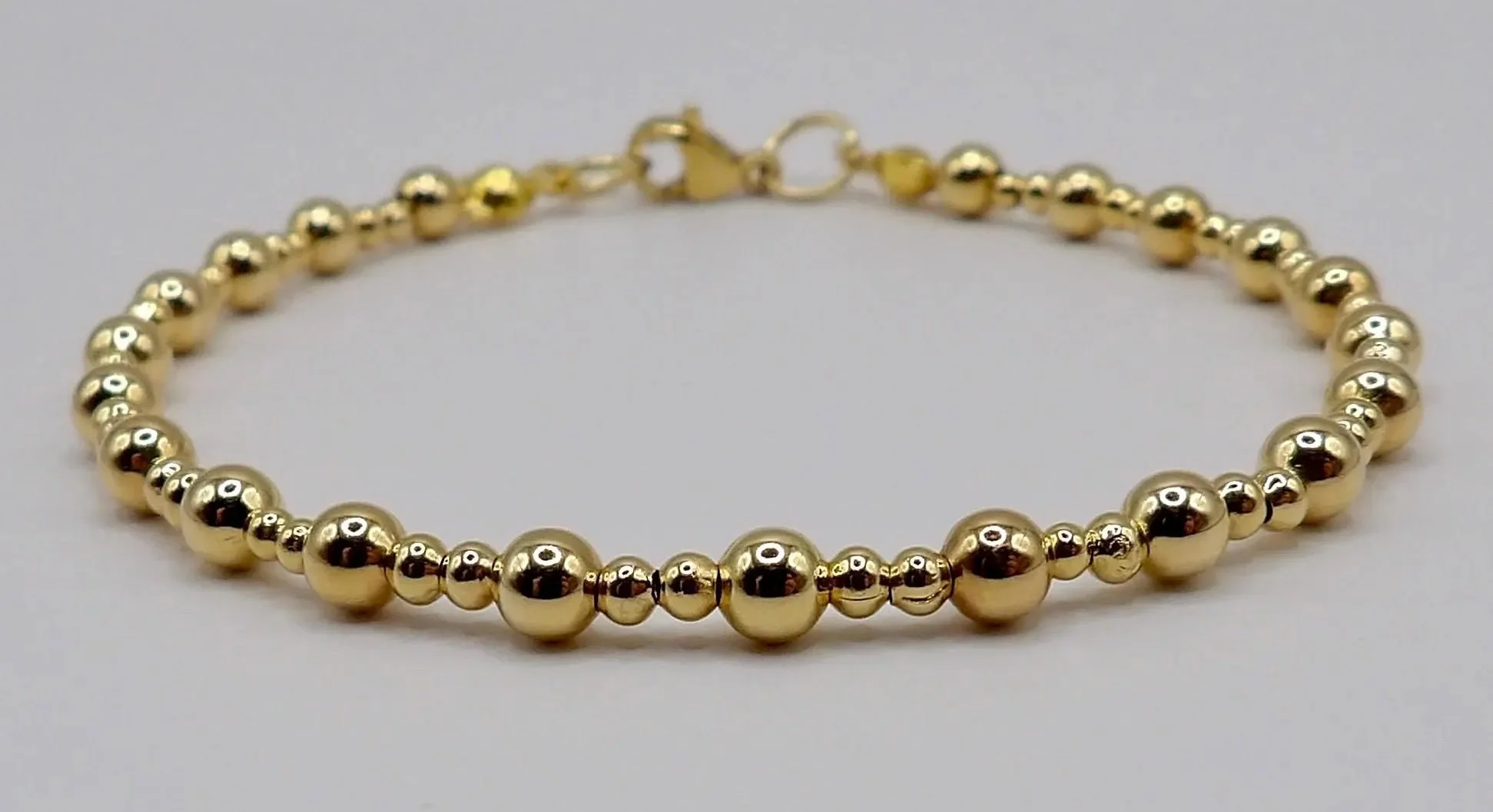 the festive starlight stack arranged to showcase the unique textures of each individual layer, from dainty gold beads to bold red glass statement pieces.