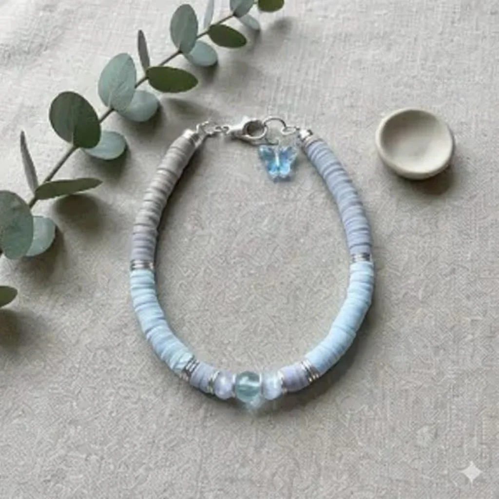 a personalized sterling silver jewelry piece showing the delicate butterfly focal against a custom-selected heishi bead background.