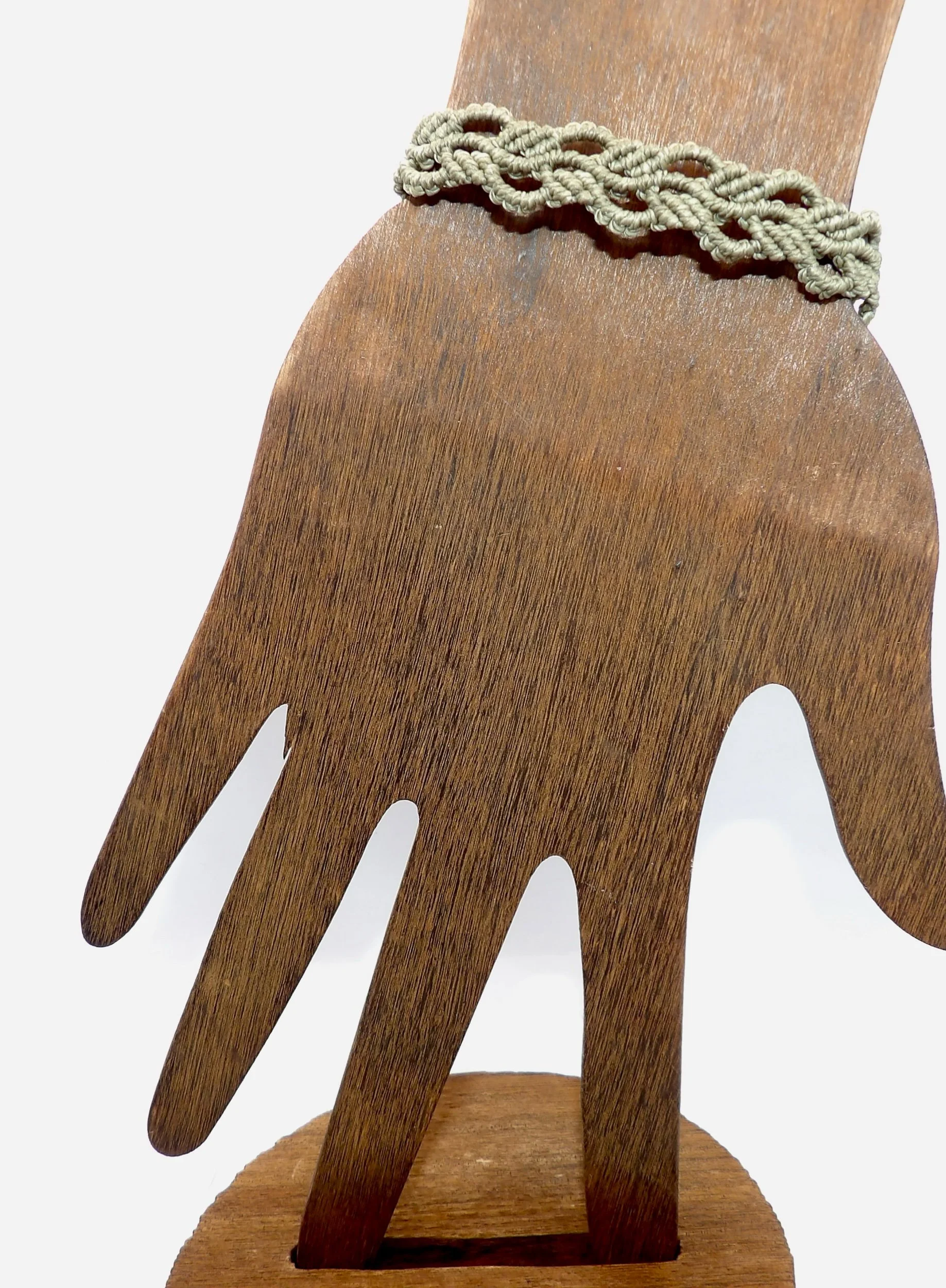 view of the adjustable sliding knot closure on the handmade green ivy leaf waxed cord macrame bracelet.