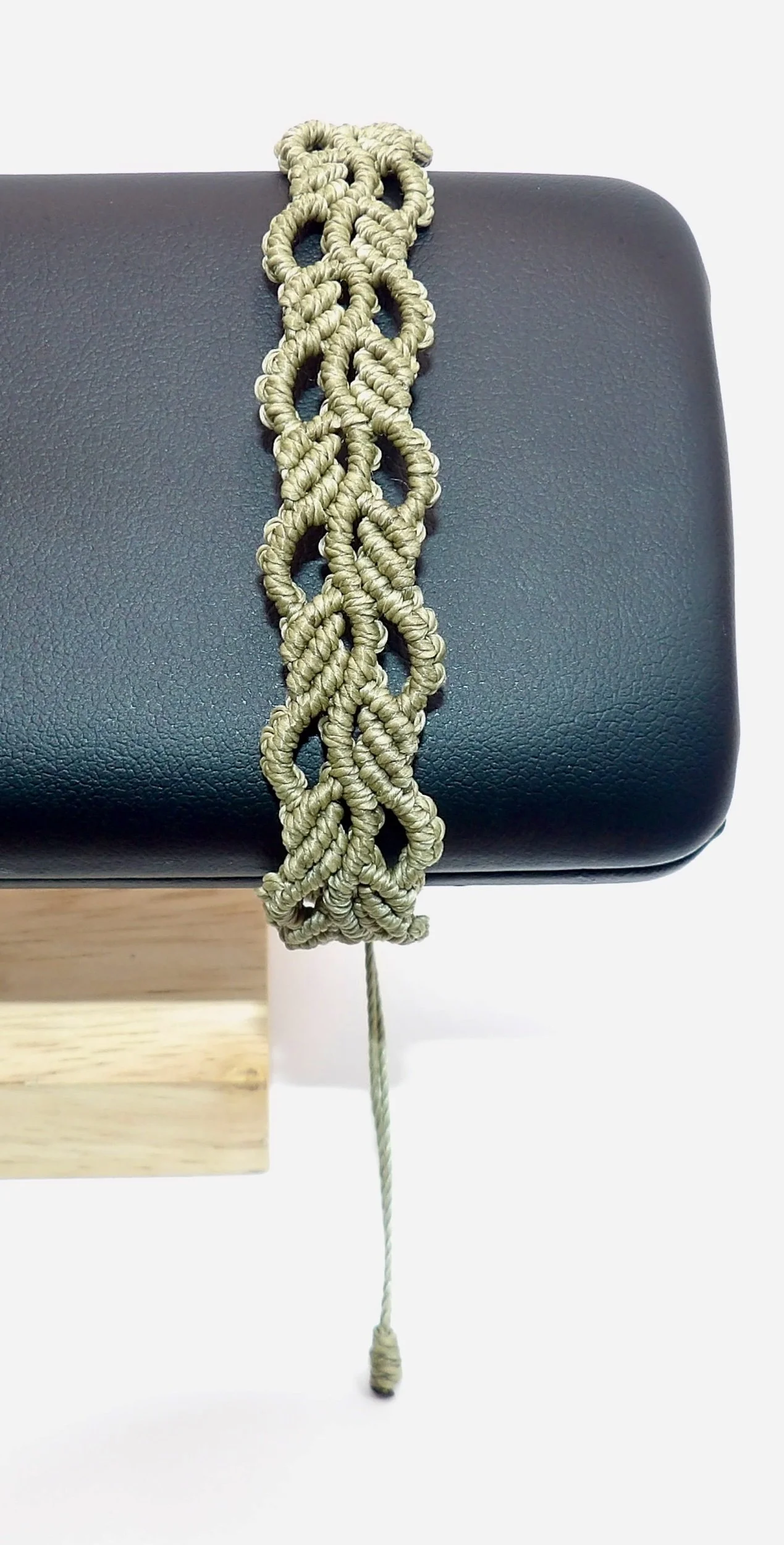 view of the adjustable sliding knot closure on the handmade green ivy leaf waxed cord macrame bracelet.