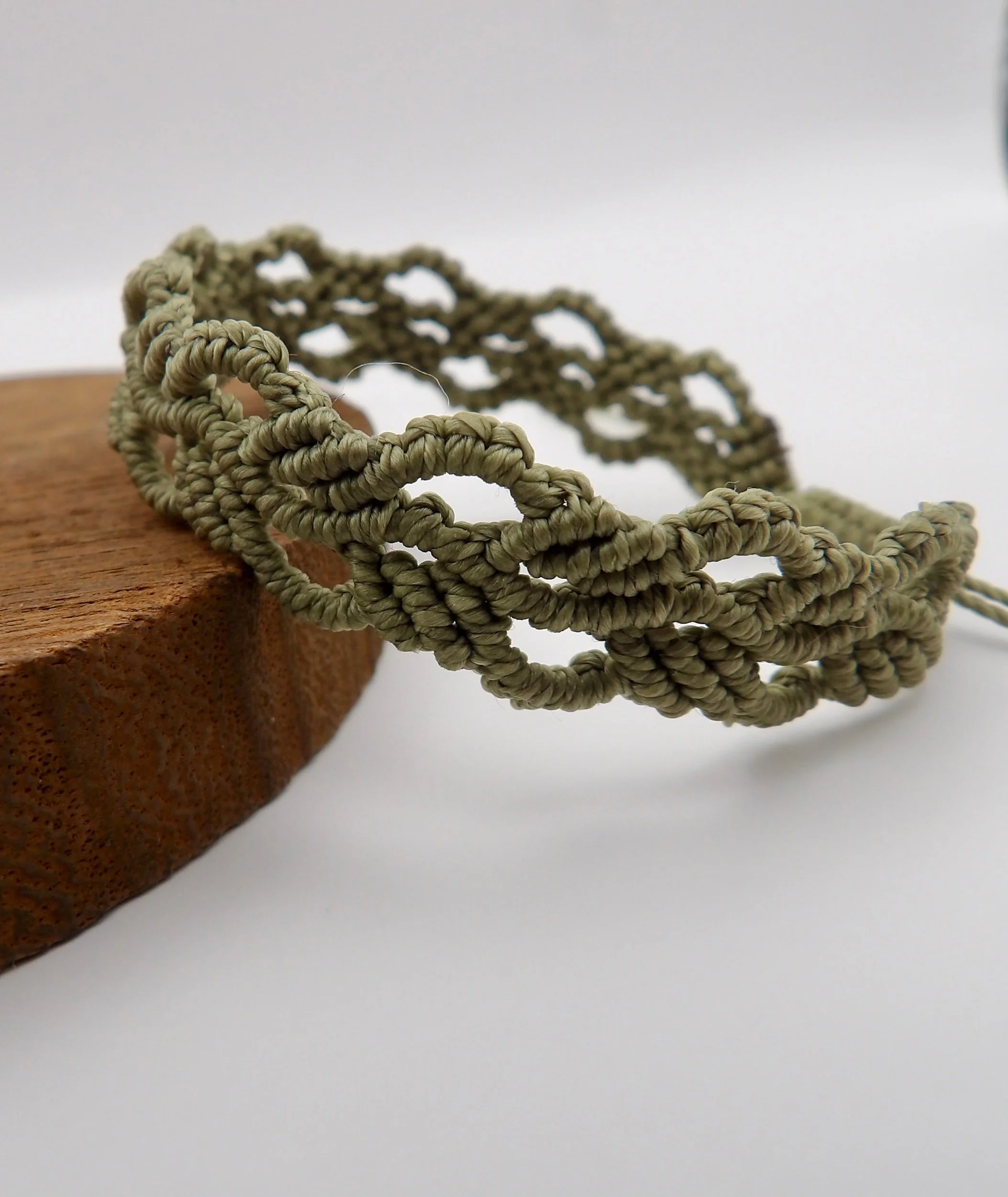 view of the adjustable sliding knot closure on the handmade green ivy leaf waxed cord macrame bracelet.