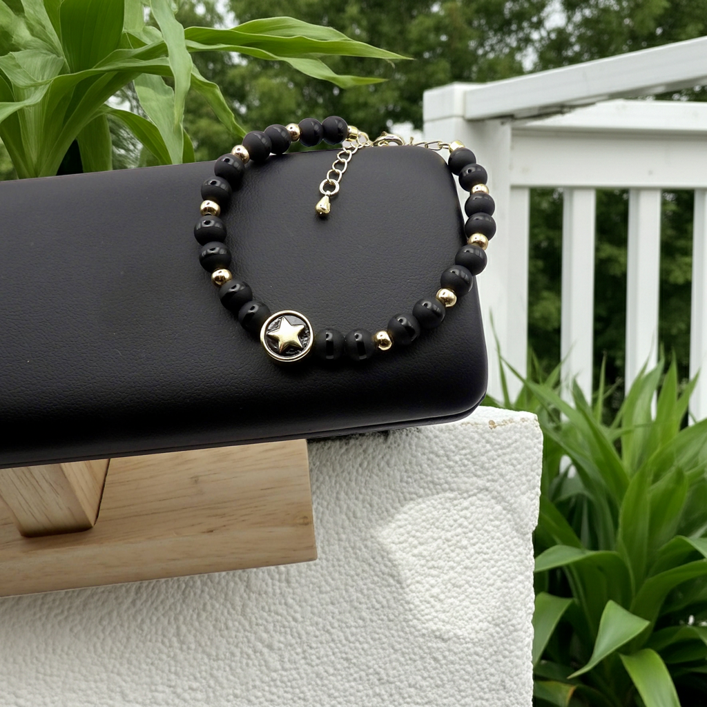 view of the 18k gold lobster clasp and extender chain on the handmade black tuxedo onyx beaded bracelet.