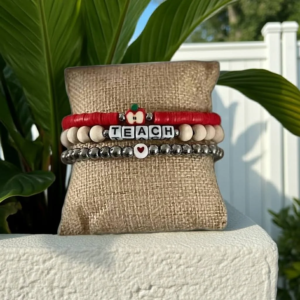 handmade 3-piece teacher appreciation set stacked: 6mm stainless steel colored glass bead bracelet, wood "teach" bracelet, & red heishi apple charm bracelet.