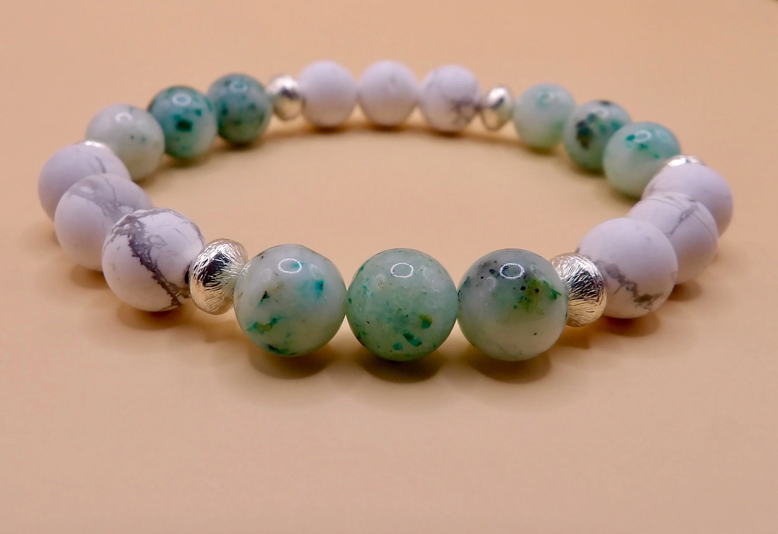 close-up detail showing the 8mm smooth green chrysocolla beads and 6mm brushed sterling silver accents on the gemstone stretch bracelet.
