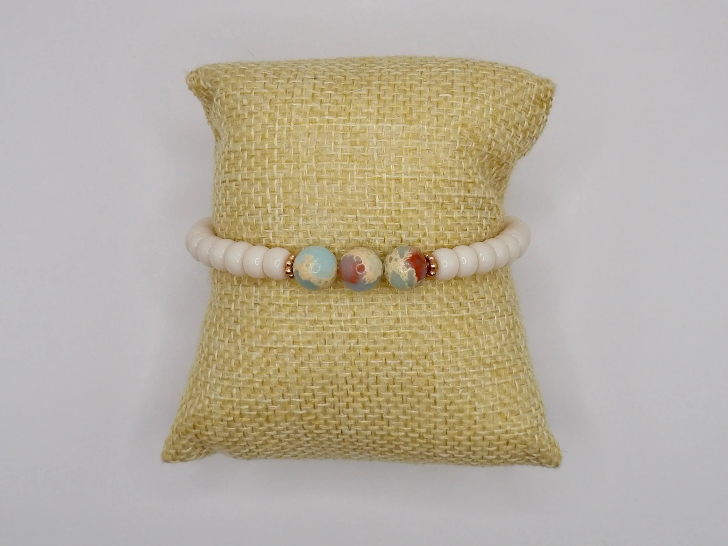 person wearing the dainty cream heishi and blue opal bracelet, showcasing its adjustable fit and boho-luxe style.