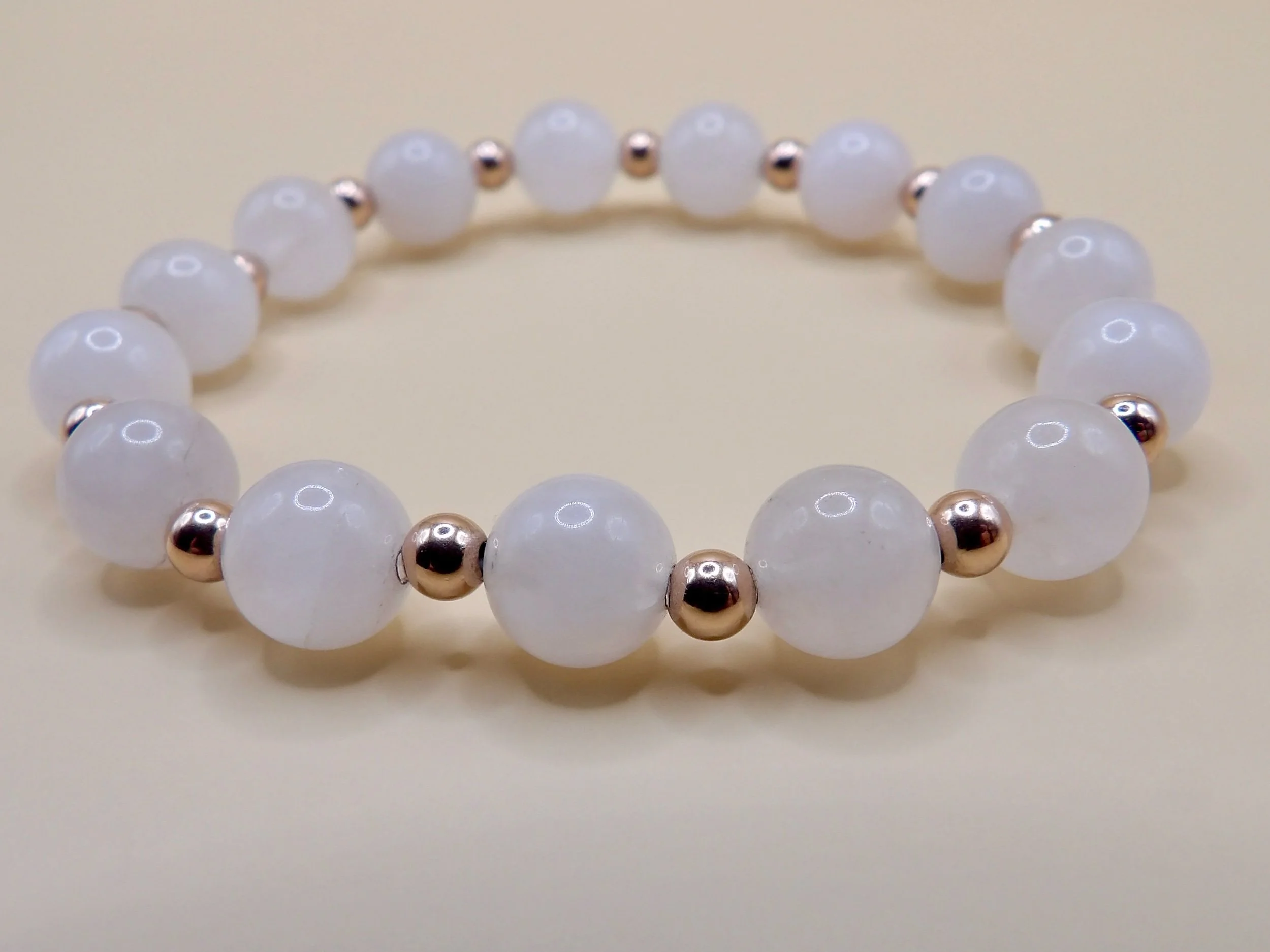 detail of the fine jewelry stretch bracelet with alternating 8mm polished rose quartz and 4mm solid 14k rose gold beads.