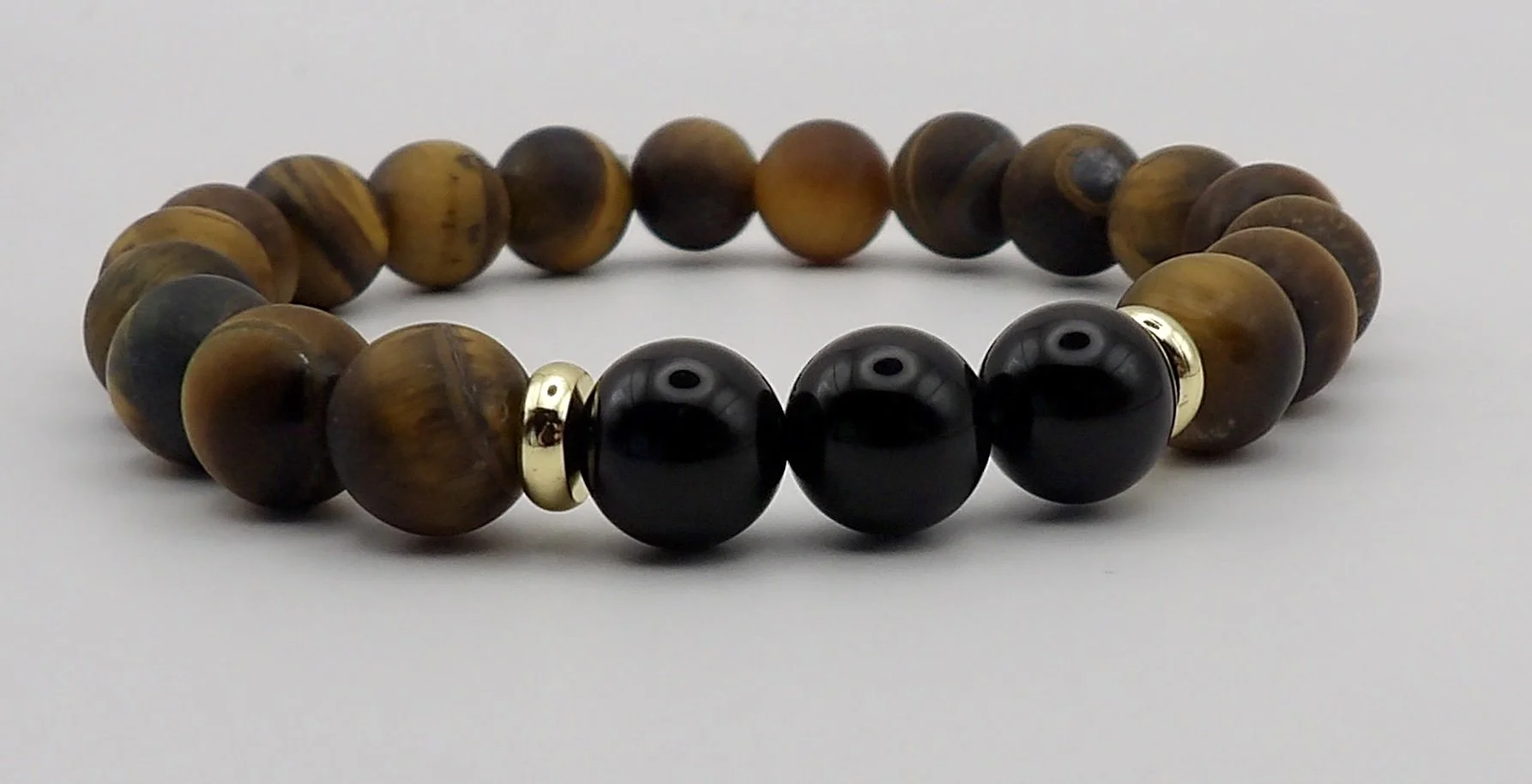 single 18k gold and tigers eye stretch bracelet with onyx centerpiece, available as part of a set.
