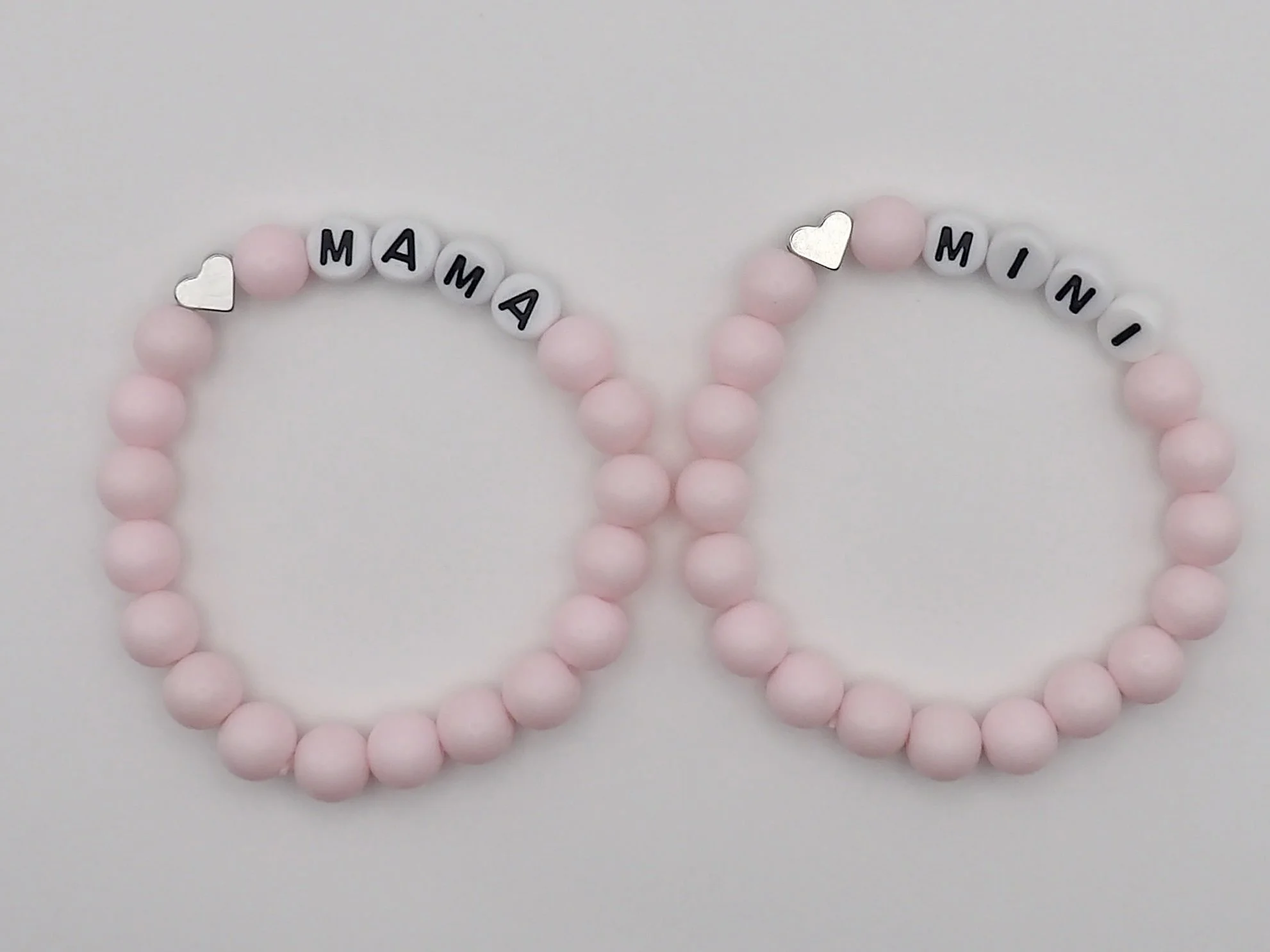 handmade "mama and mini" mommy and me bracelet set in powder pink with .925 sterling silver heart charms.