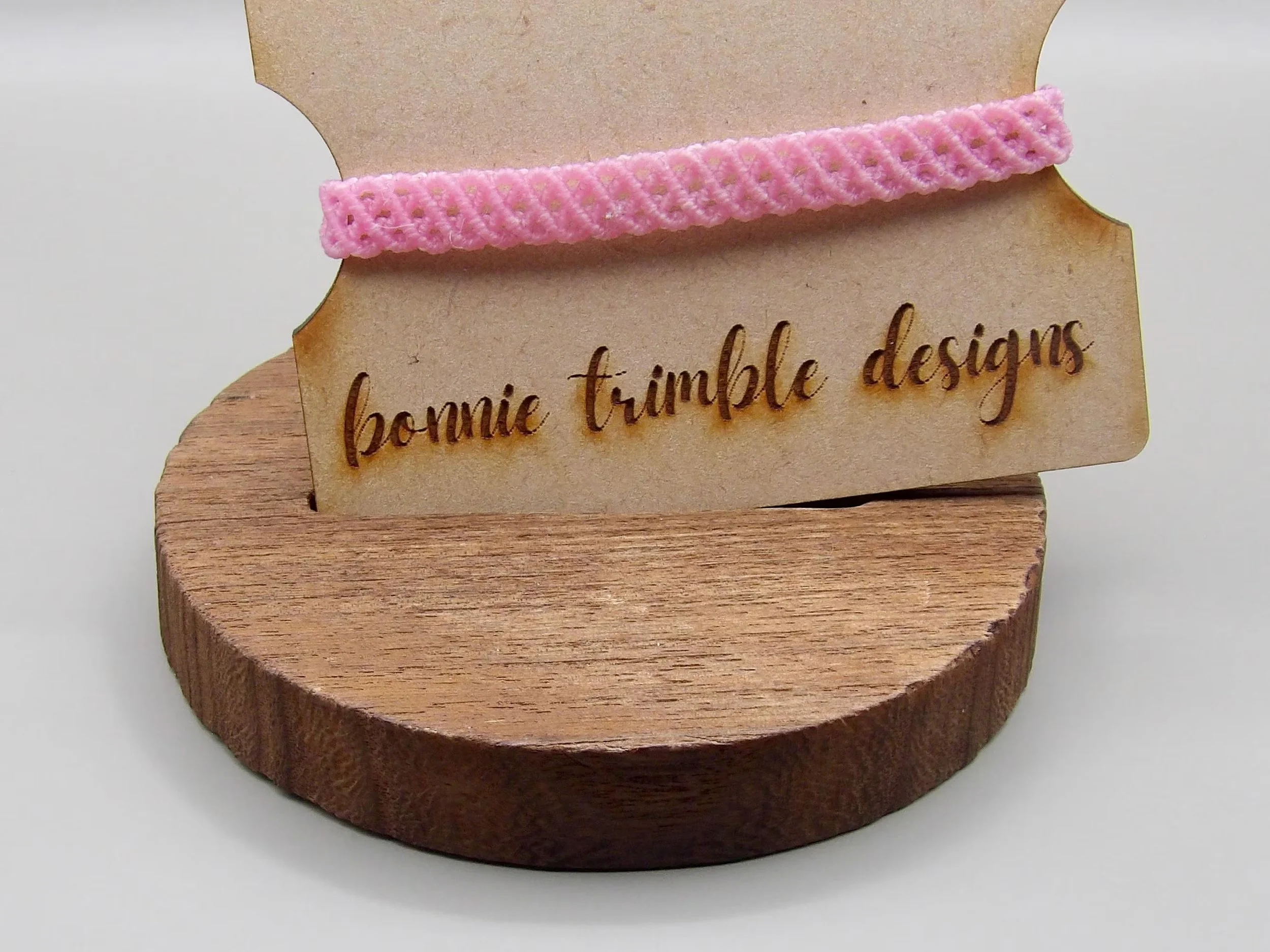the pink lace bracelet styled for a bridal or bridesmaid look, emphasizing its airy texture and high-end gold finish.