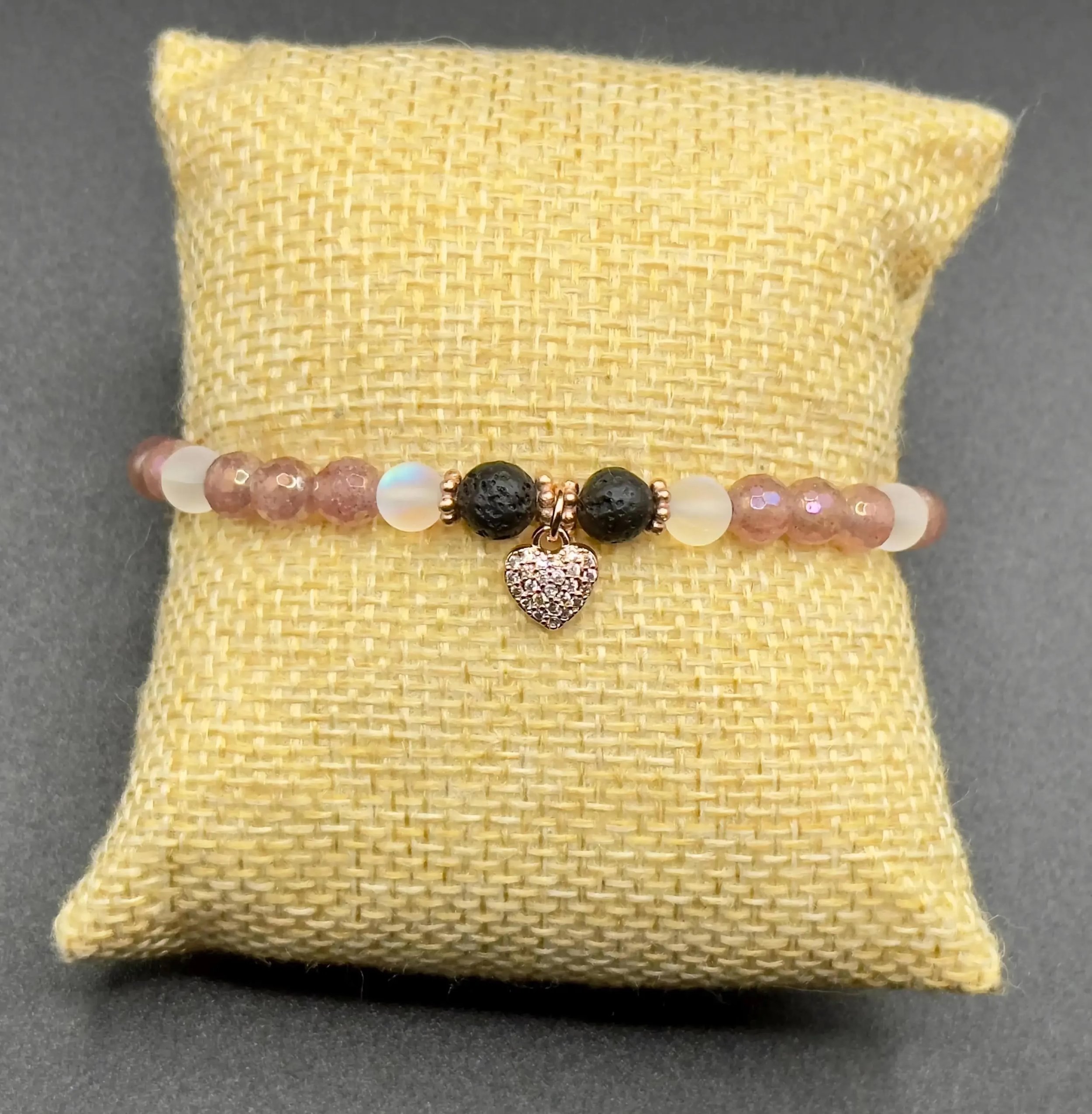 the dreamy romantic bracelet styled with a bottle of essential oil to showcase its functional aromatherapy design.
