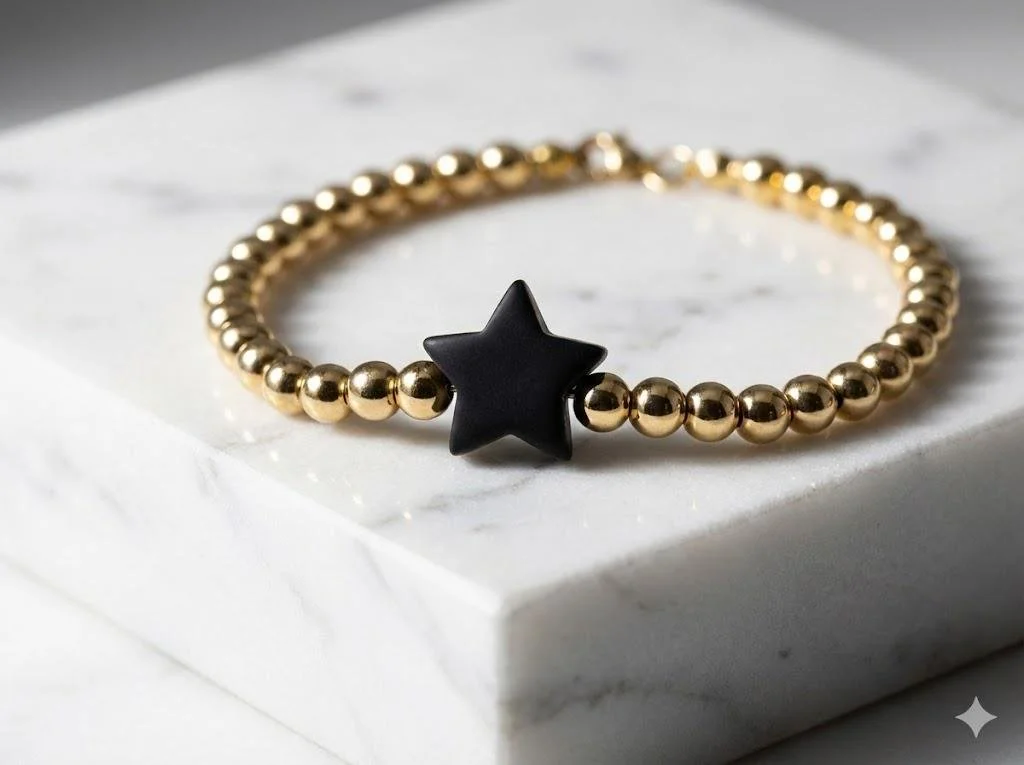 close-up of 18k gold plated round beads and a smooth matte silicone star bead in the center.