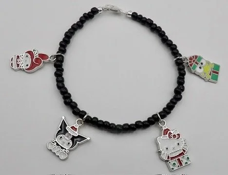 close-up detail of the sterling silver & enamel hello kitty charm in a santa hat, popping out of a green present.